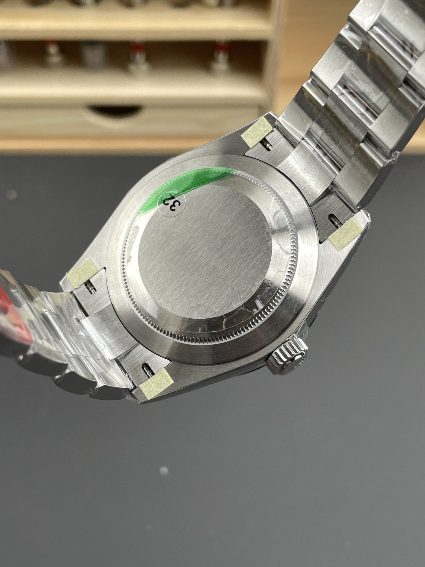 Gebürsteter Gehäuseboden einer Rolex-Clone-Uhr mit verschraubtem Boden, Oyster-Band und Schutzfolien