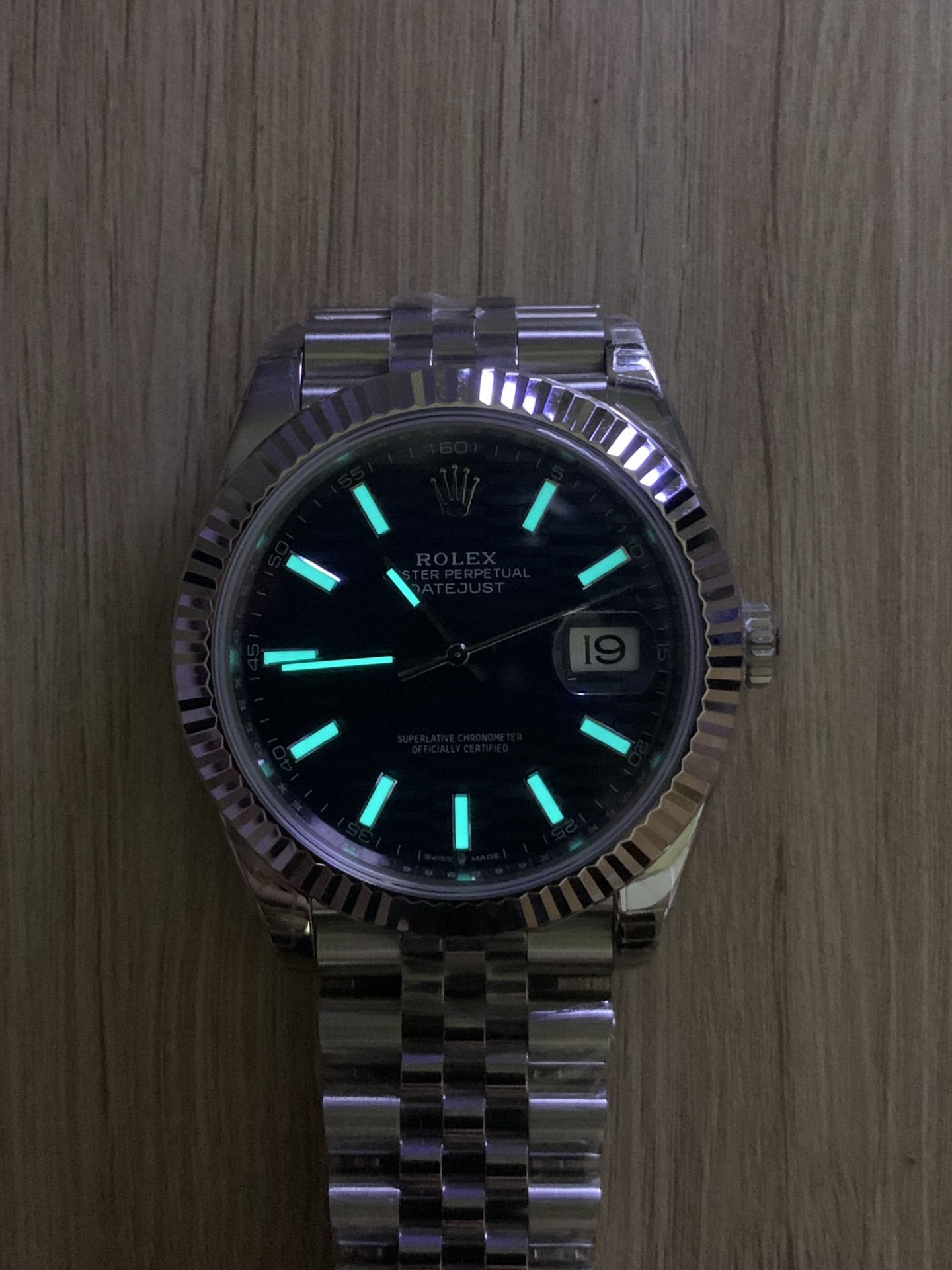 Rolex Datejust replica lume glowing brightly in the dark, highlighting the hour markers and hands