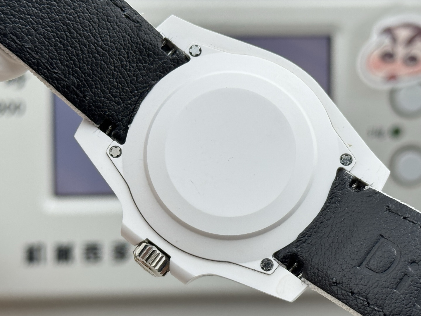 Caseback of the white ceramic replica watch with stainless steel screws and black leather strap