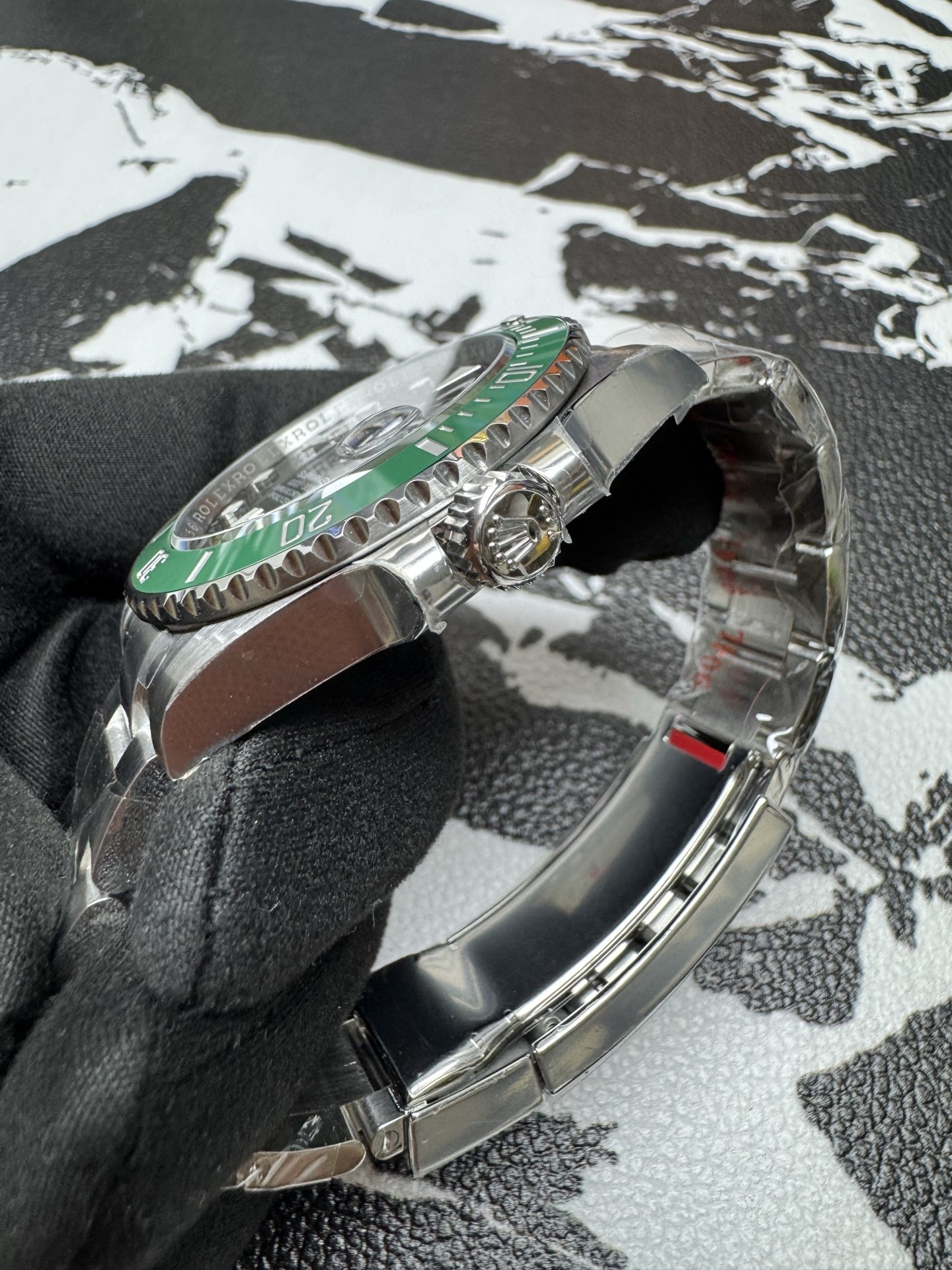 Replica Rolex Submariner side profile showing green bezel and winding crown