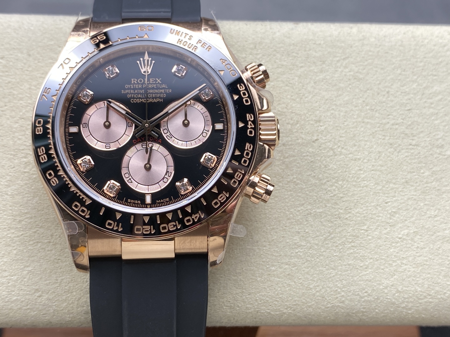 Reloj replica Rolex Daytona en oro rosa con esfera negra, marcadores de diamantes y correa de caucho