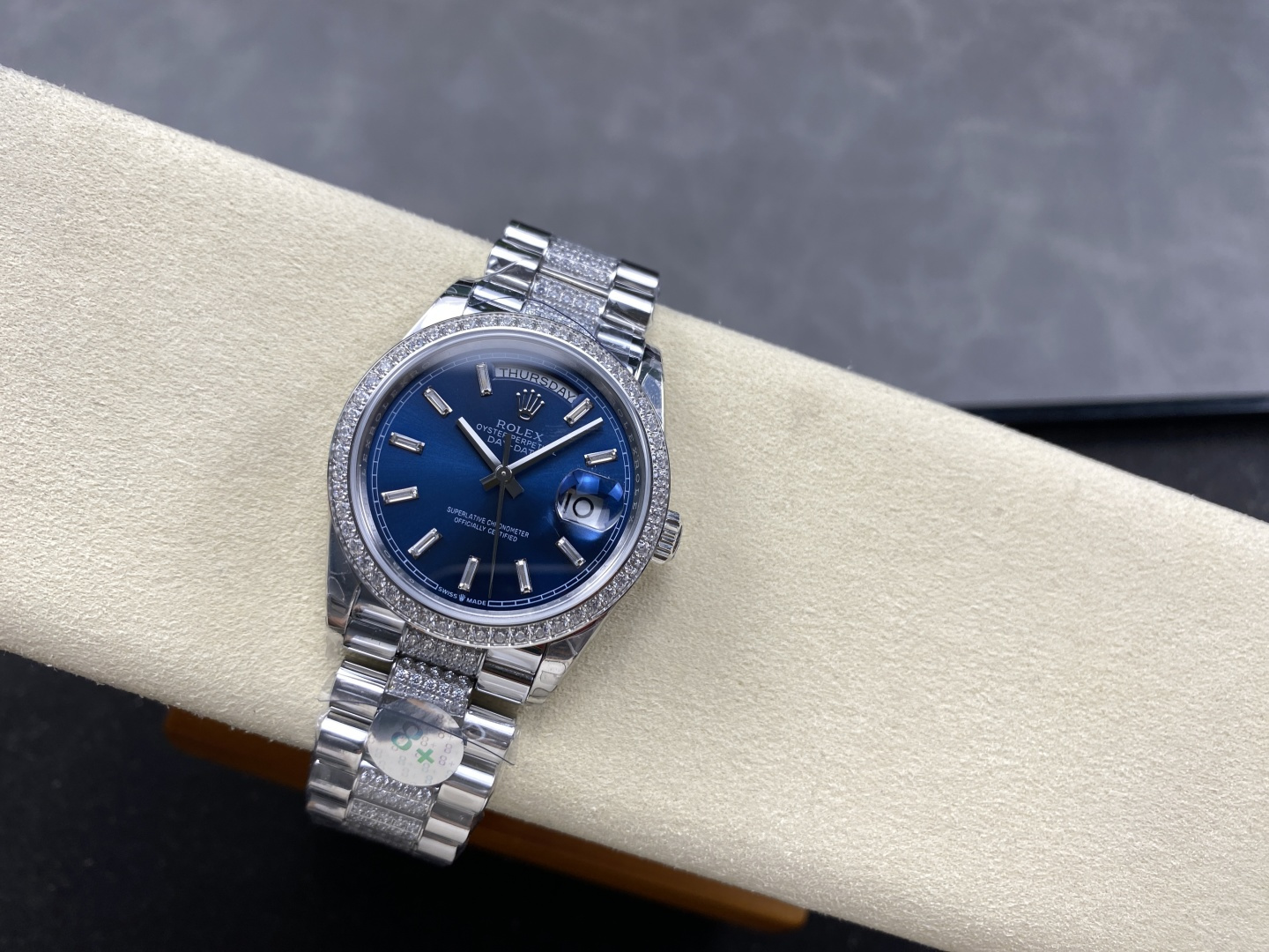 Rolex replica watch on wrist with blue dial and diamond-set bracelet