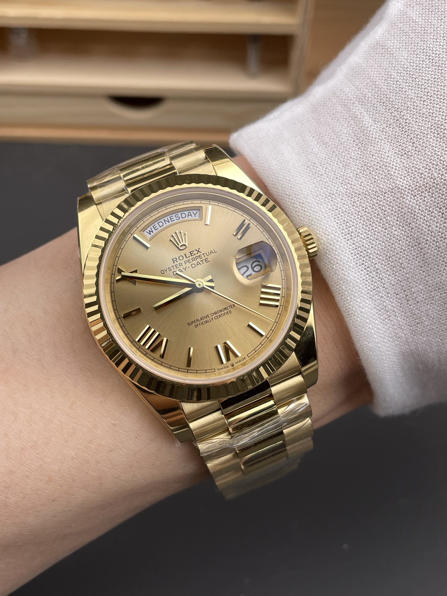 Gold Rolex Day-Date replica on wrist with champagne dial