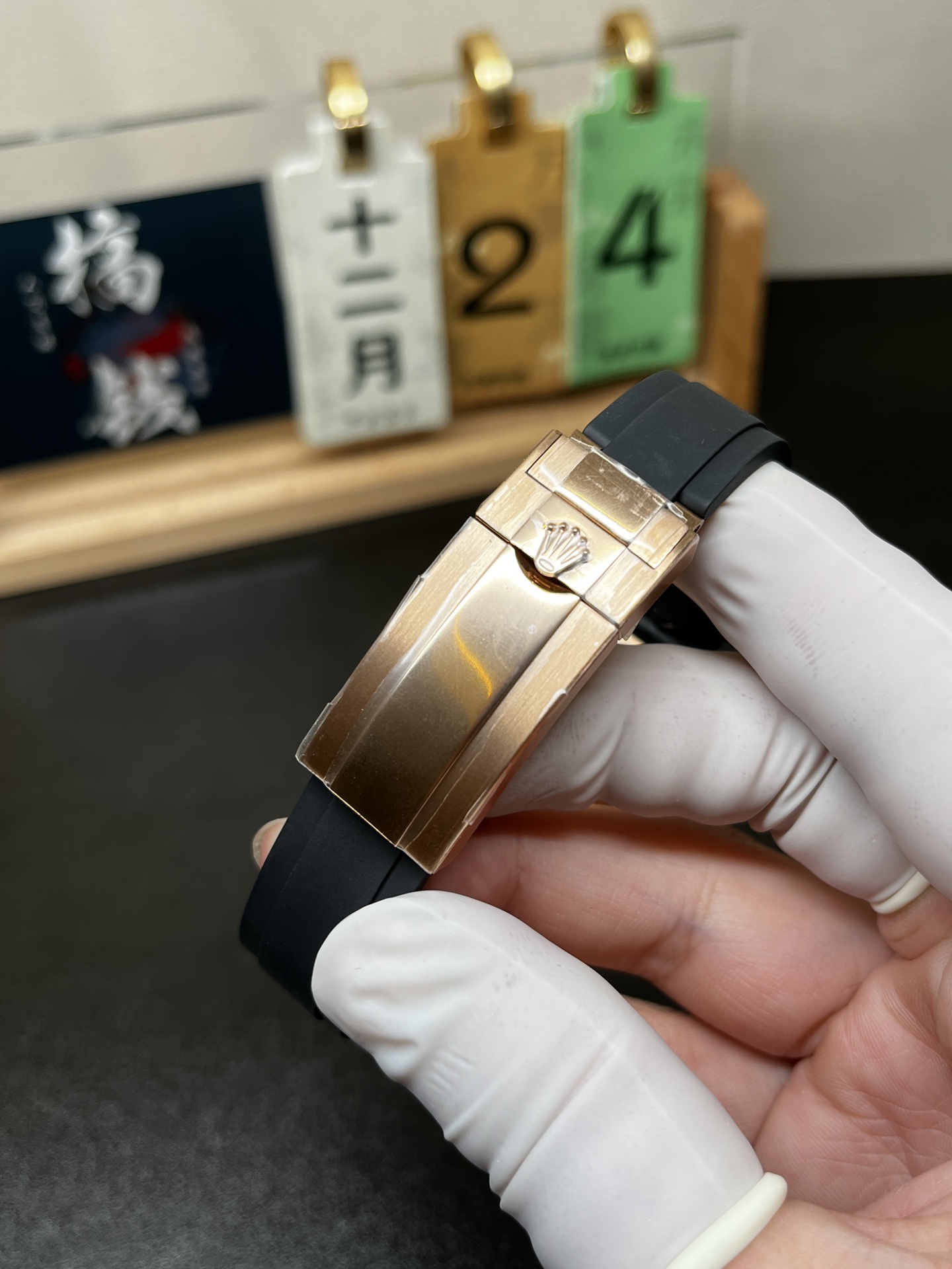 Rose gold Rolex replica clasp on black rubber strap