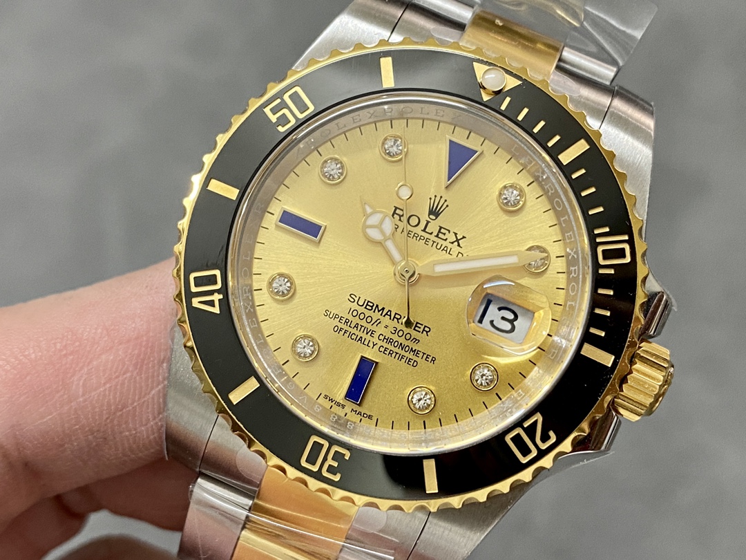Gold two-tone Rolex Submariner replica with black bezel and diamond markers on a wrist