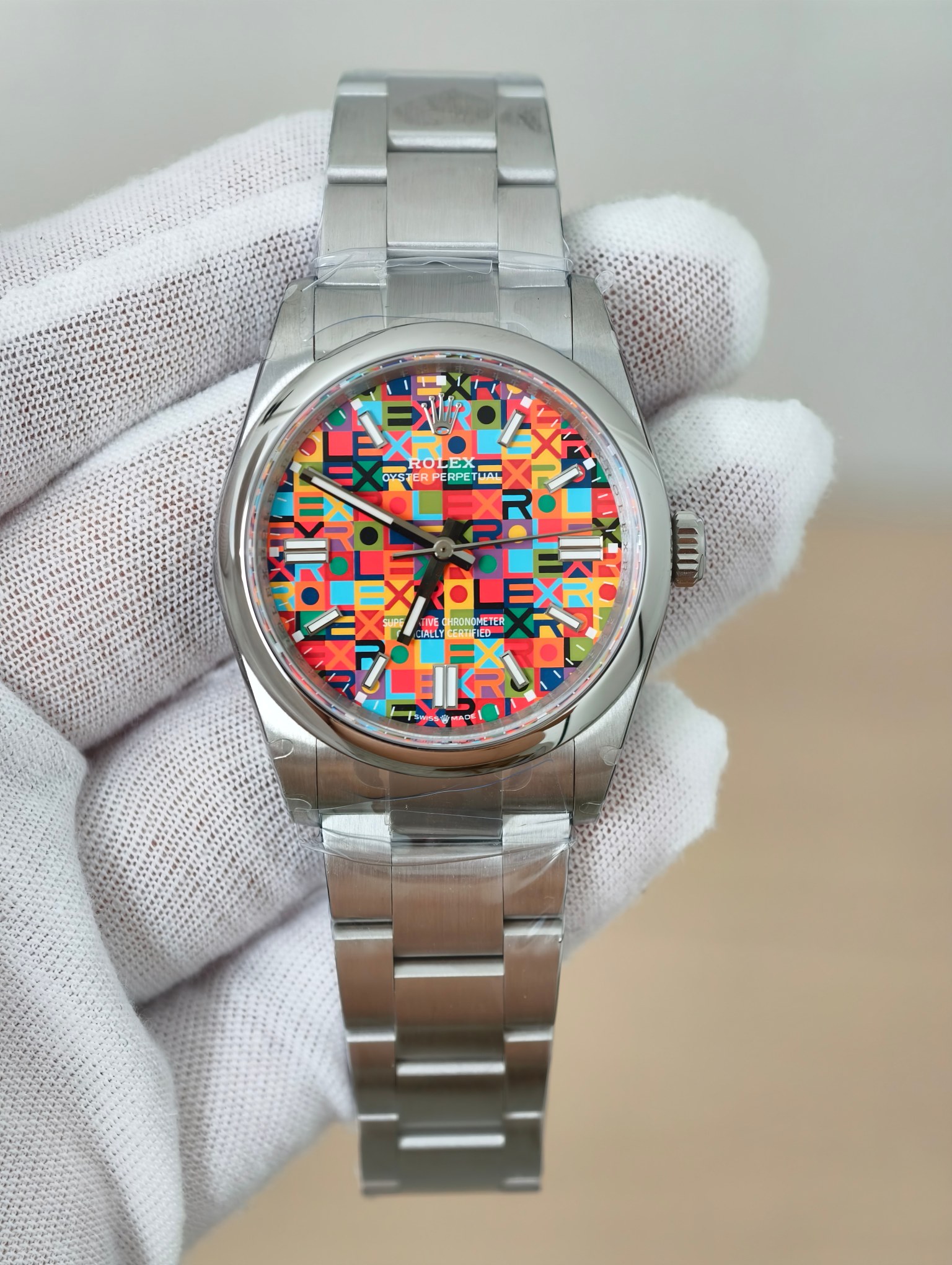 Rolex Oyster Perpetual replica with multicolor celebration dial held by a collector