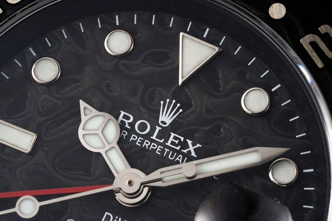 Macro shot of the dial showing carbon fiber texture, hands, and markers