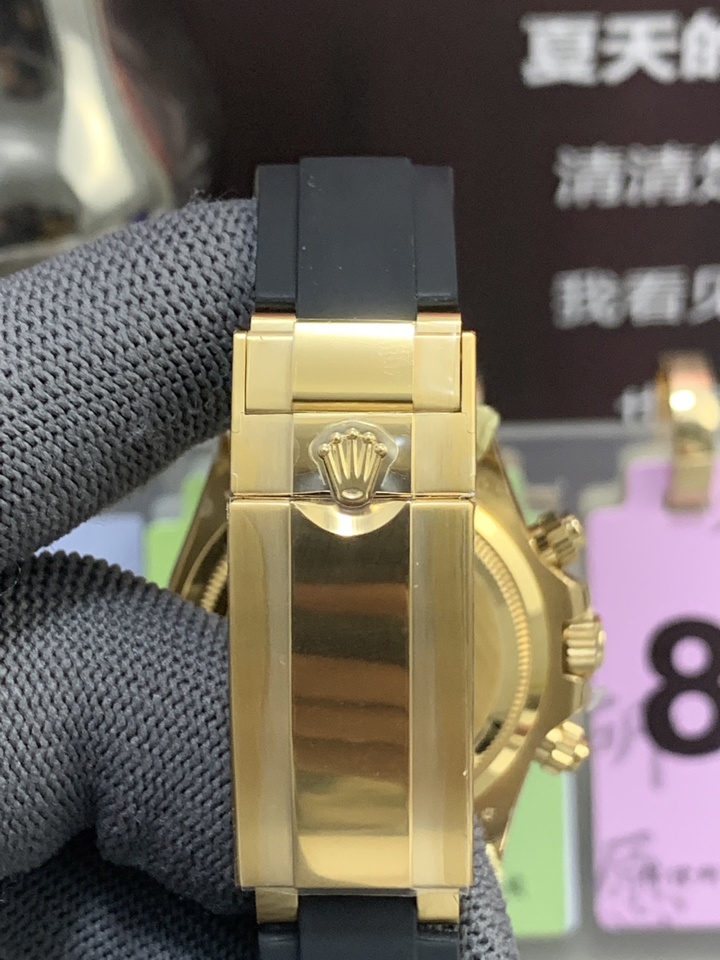 Rolex style clasp detail on black rubber strap with polished gold-tone finish