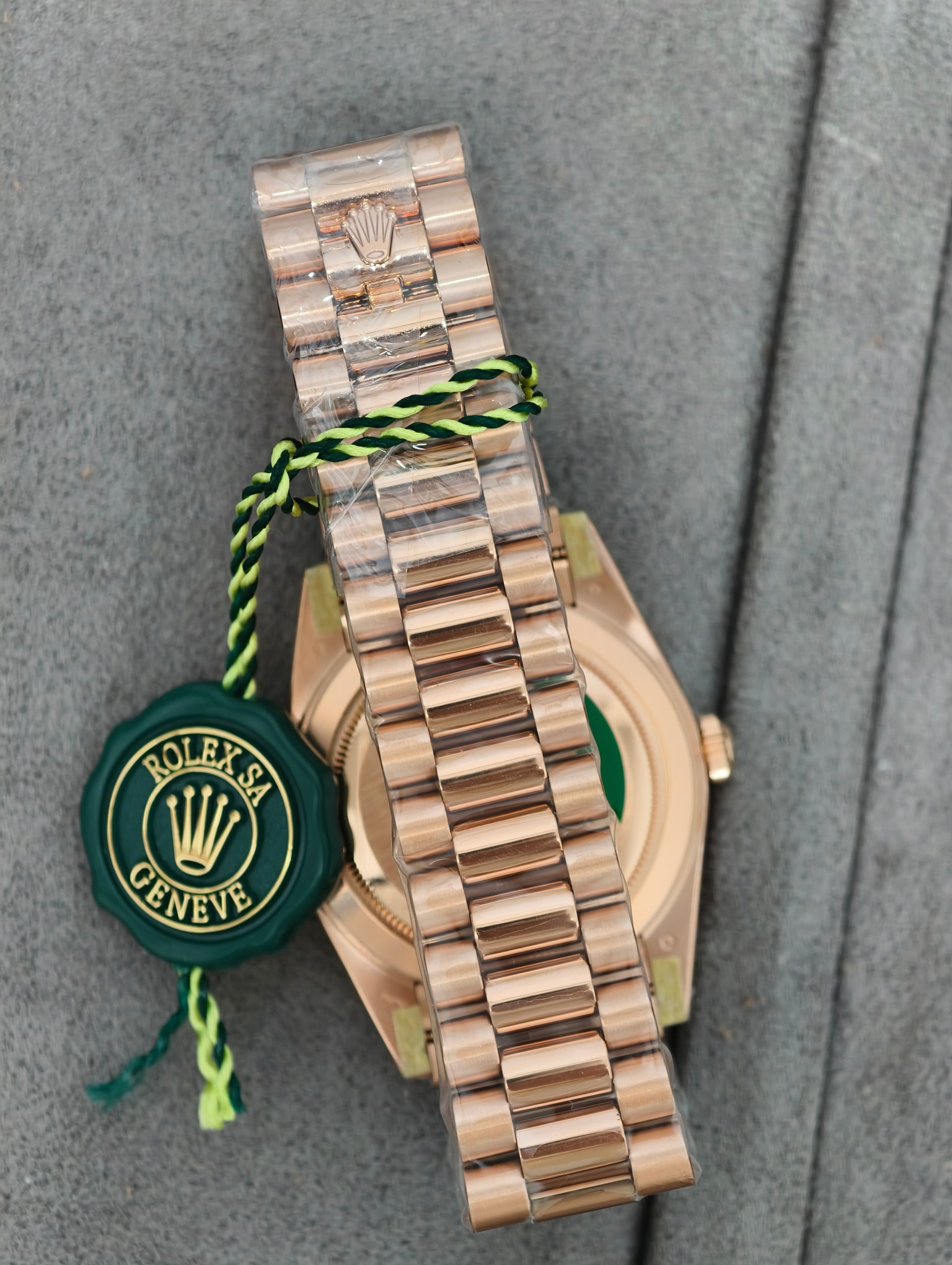 Back of the rose gold replica watch with green wax seal tag and protective elements