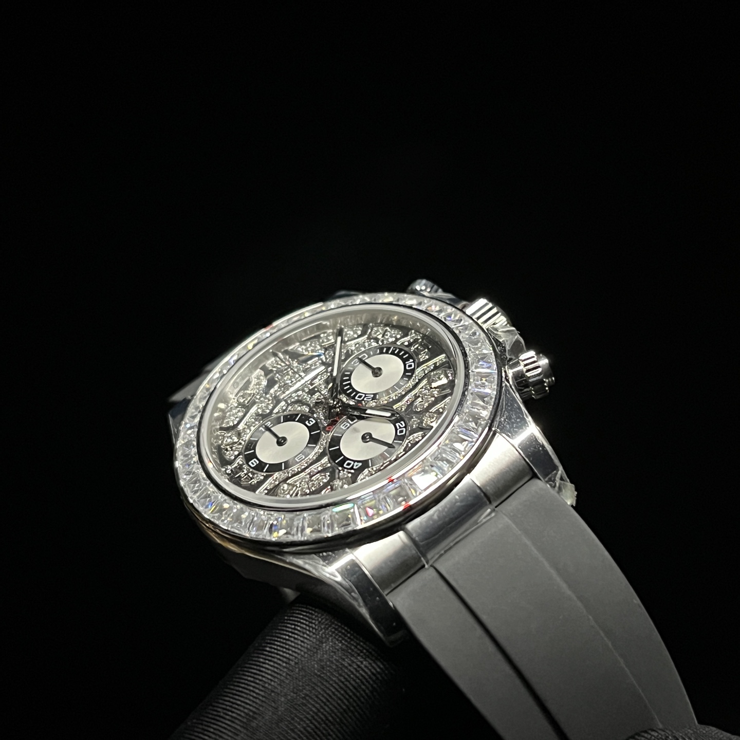 Angled Rolex Daytona style replica watch with diamond bezel and black rubber strap