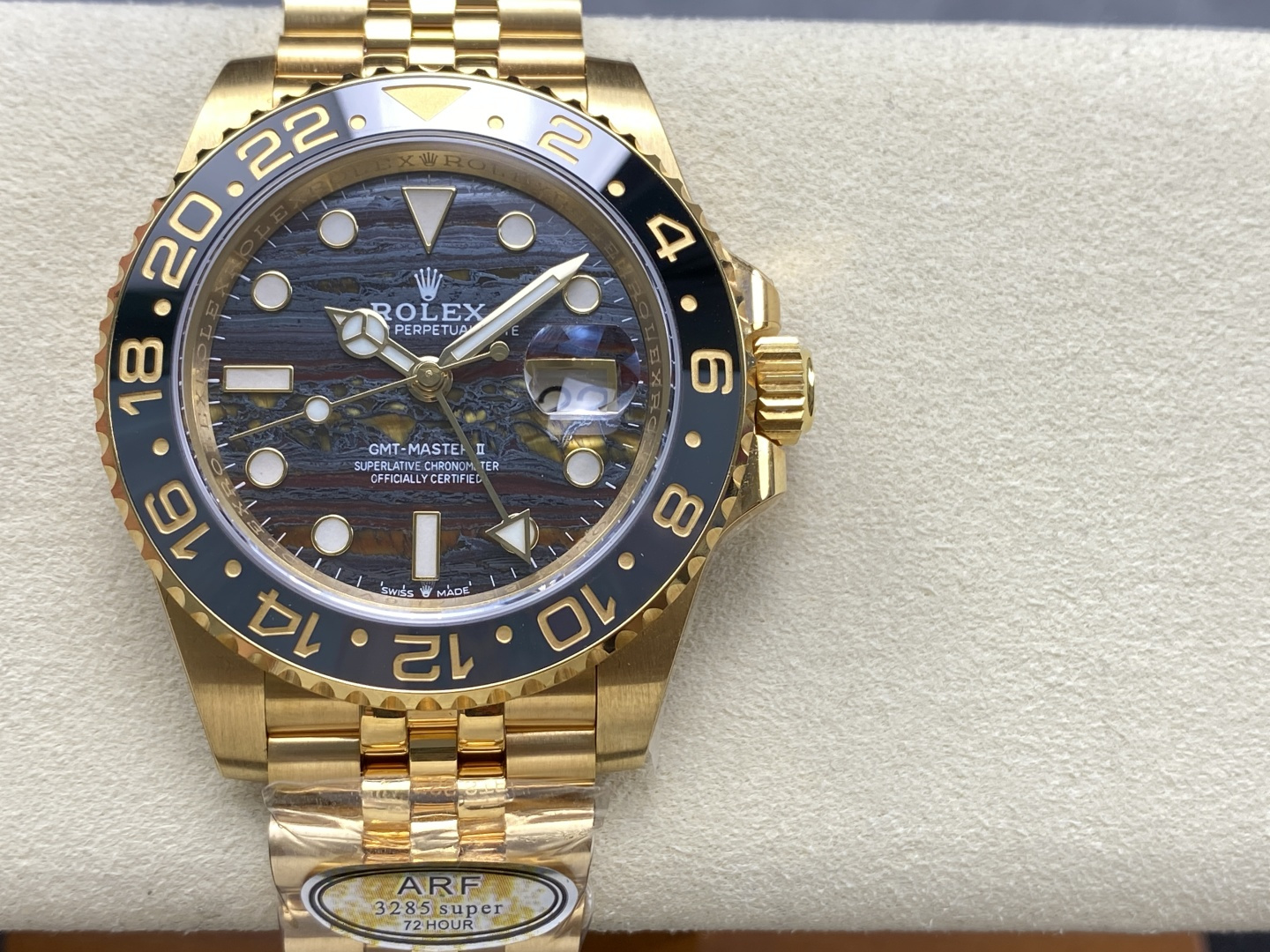 Close-up dial view of gold Rolex GMT-Master II replica with black bezel and patterned dial