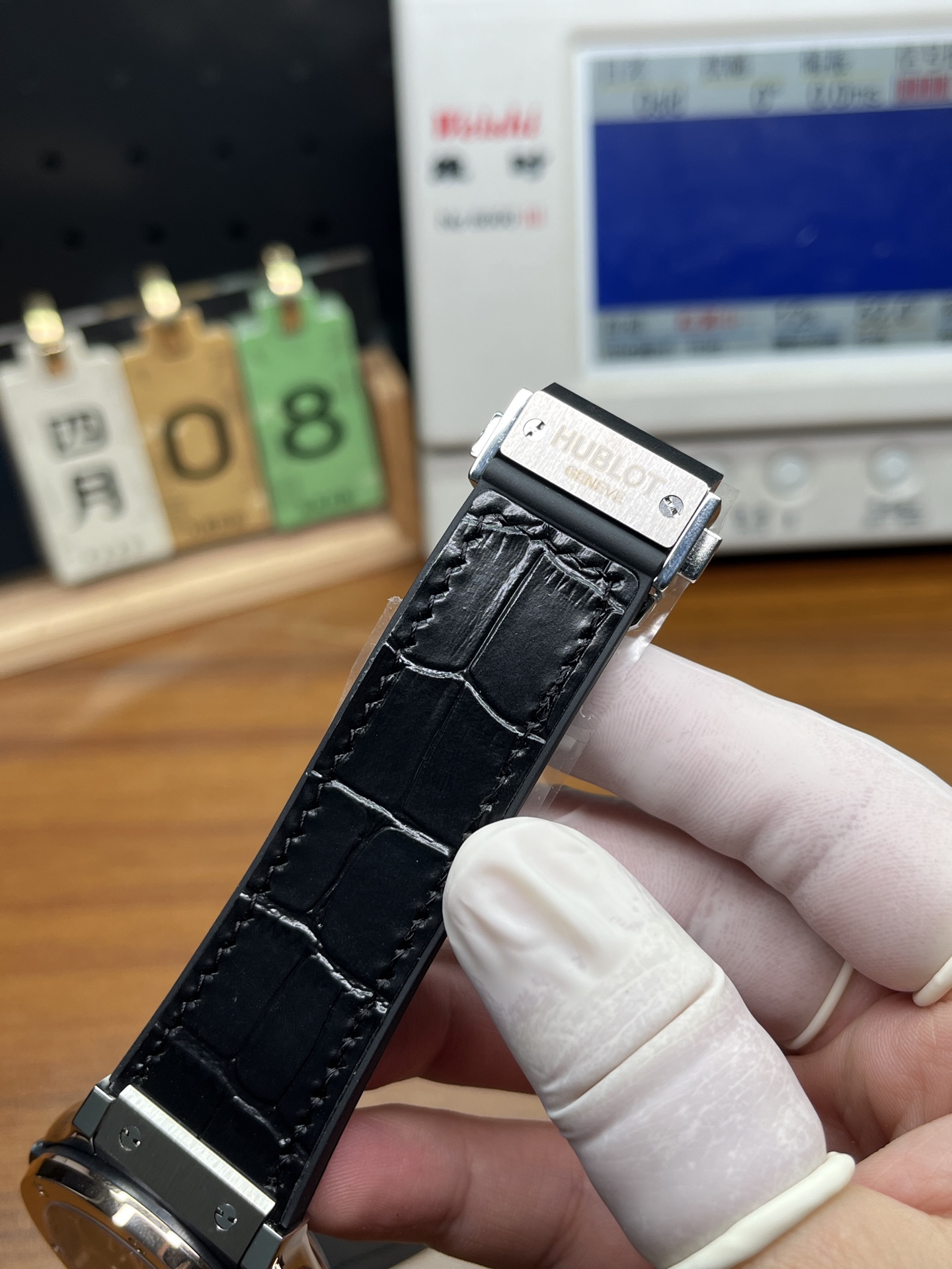 Close view of Hublot replica black strap texture stitching and metal clasp plate