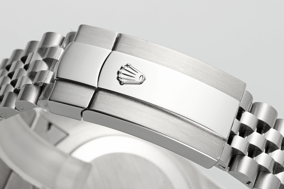 High-resolution photograph of a Rolex Sky-Dweller wristwatch featuring a deep green sunburst dial, fluted bezel, cyclops date magnifier showing 15, and Jubilee bracelet against a white background