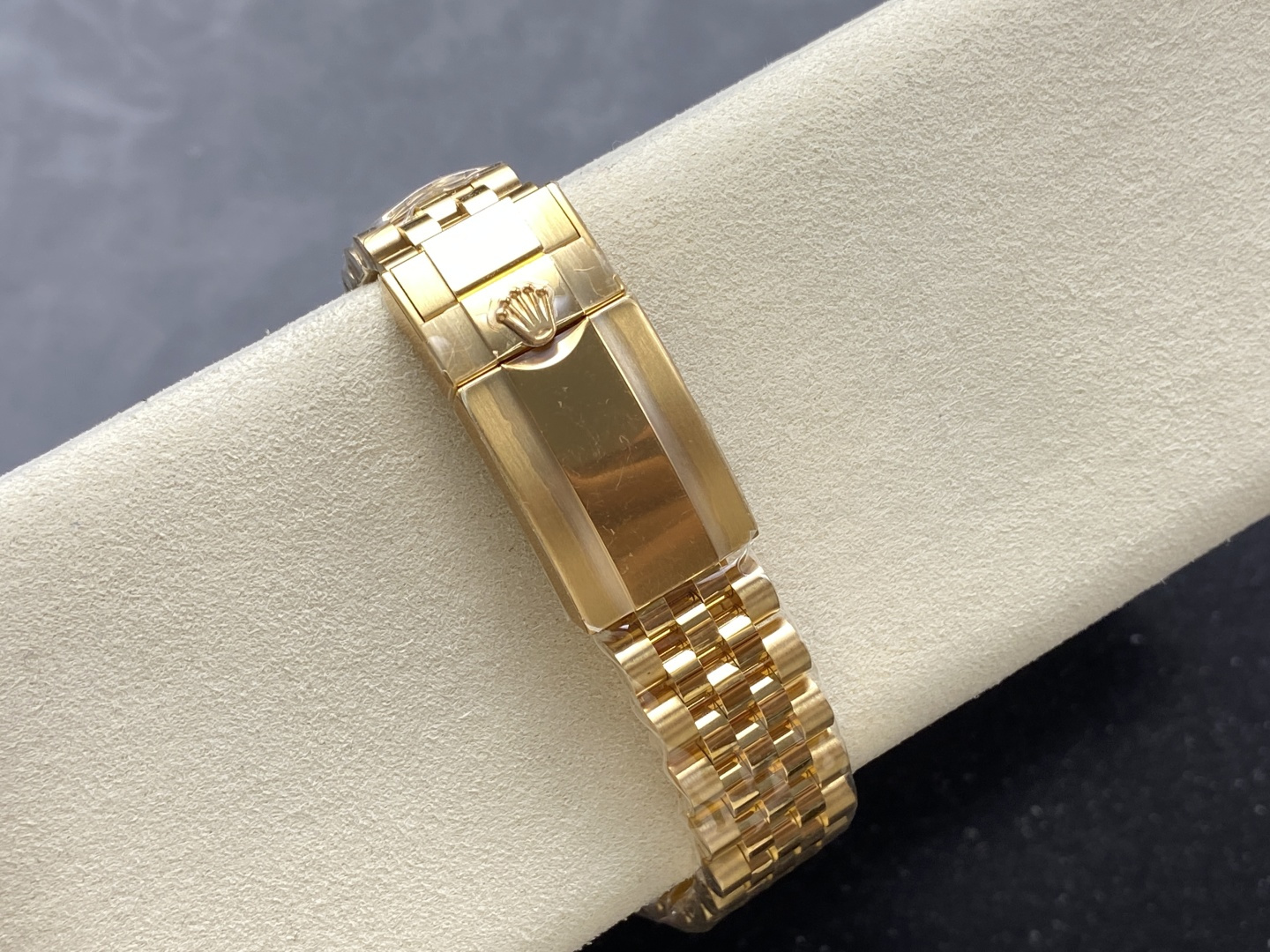 Gold Rolex replica Jubilee bracelet clasp with crown logo on watch cushion
