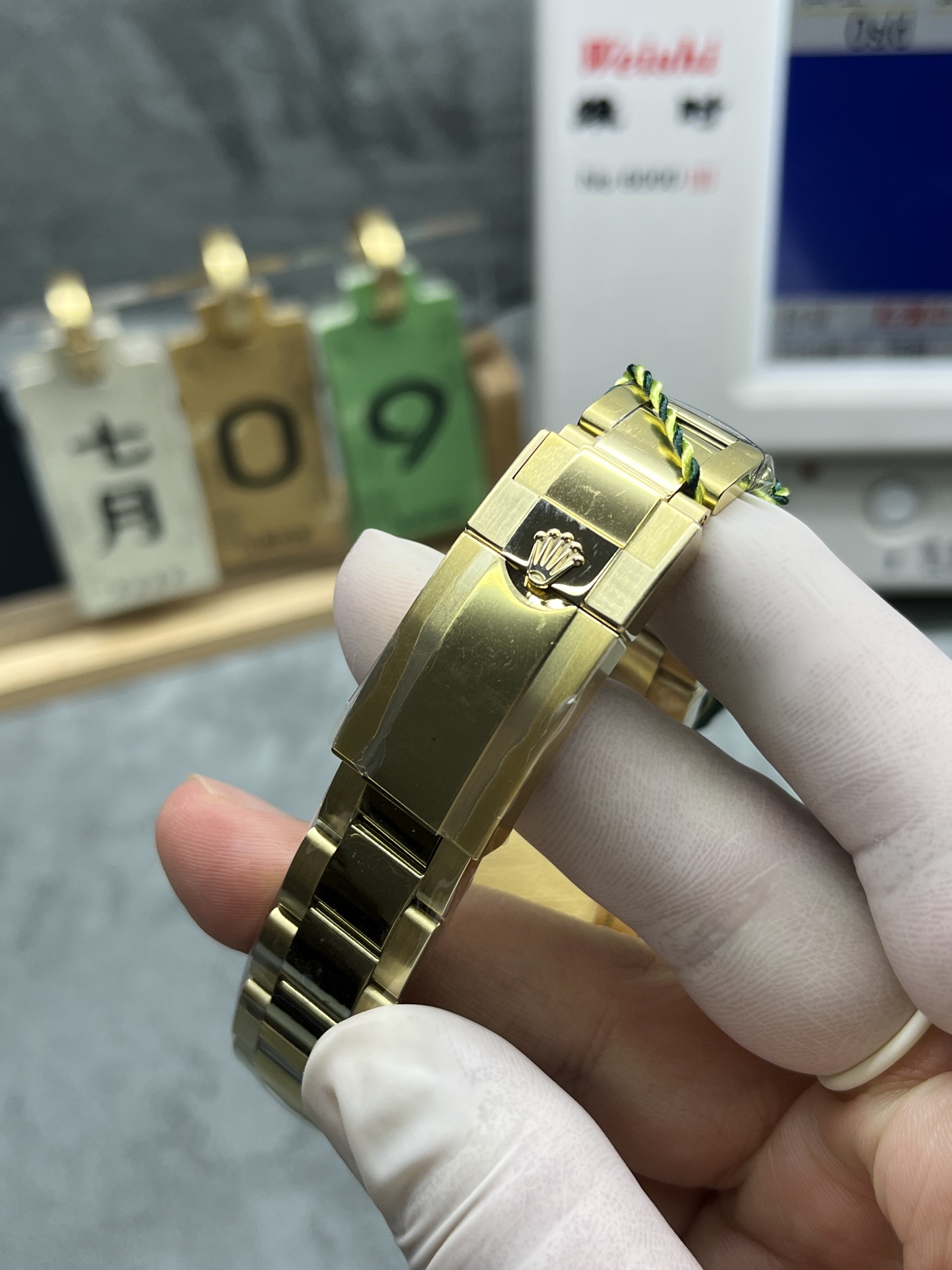 Close-up of gold buckle with Rolex crown logo on a replica Daytona