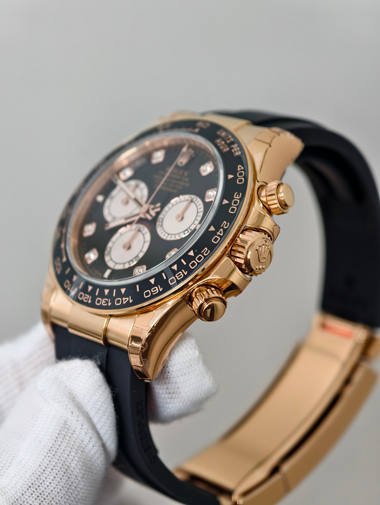 Side profile of rose gold replica chronograph with Oysterflex rubber strap and pushers