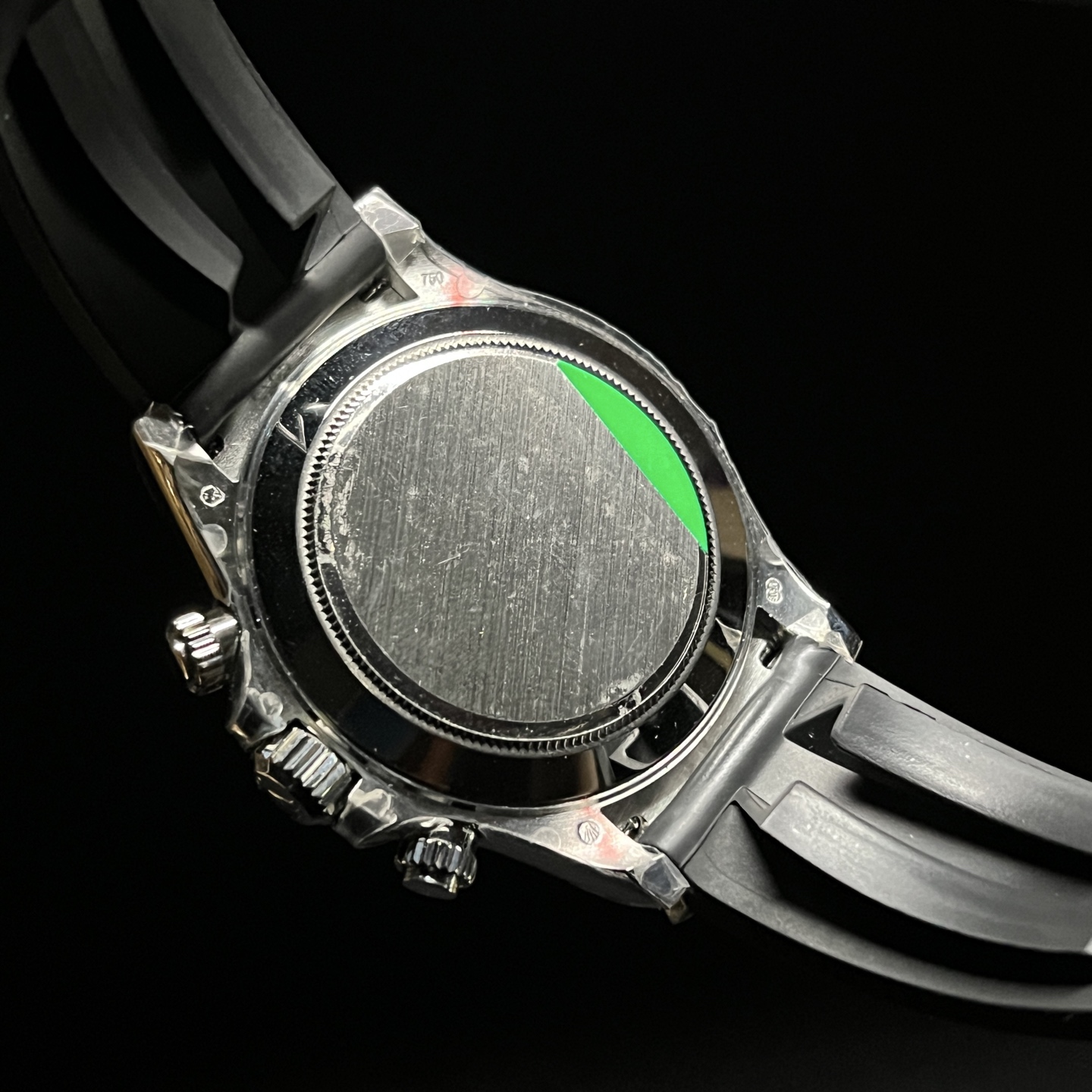 Caseback view of Rolex Daytona style replica watch with black rubber strap and protective film