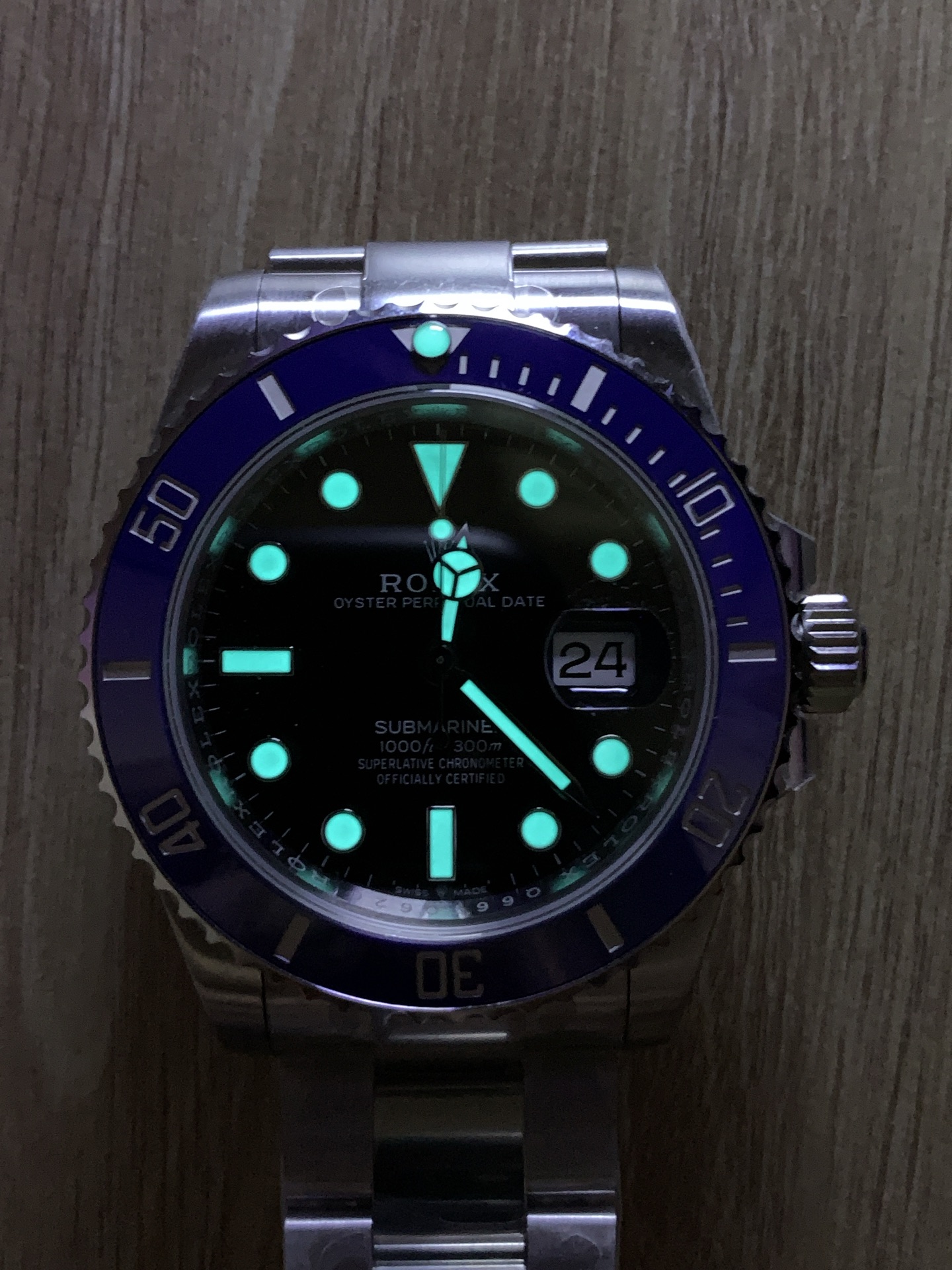 Replica Rolex Submariner style watch lume shot showing bright markers and hands in the dark