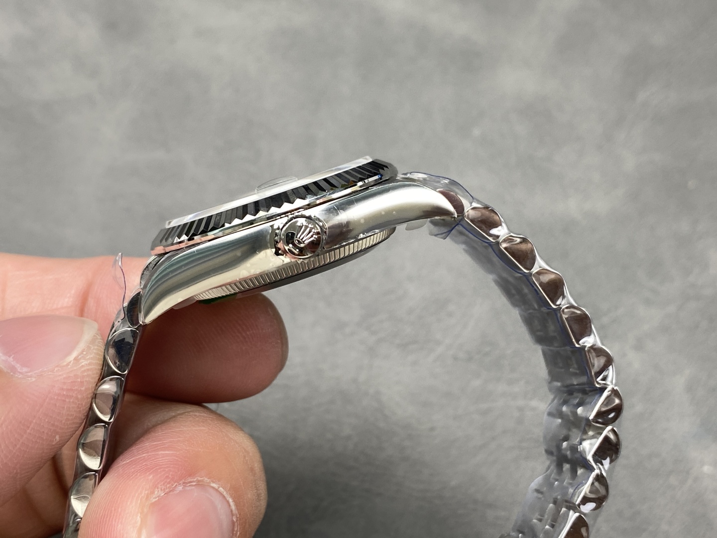 side profile of stainless steel case, fluted bezel, and crown