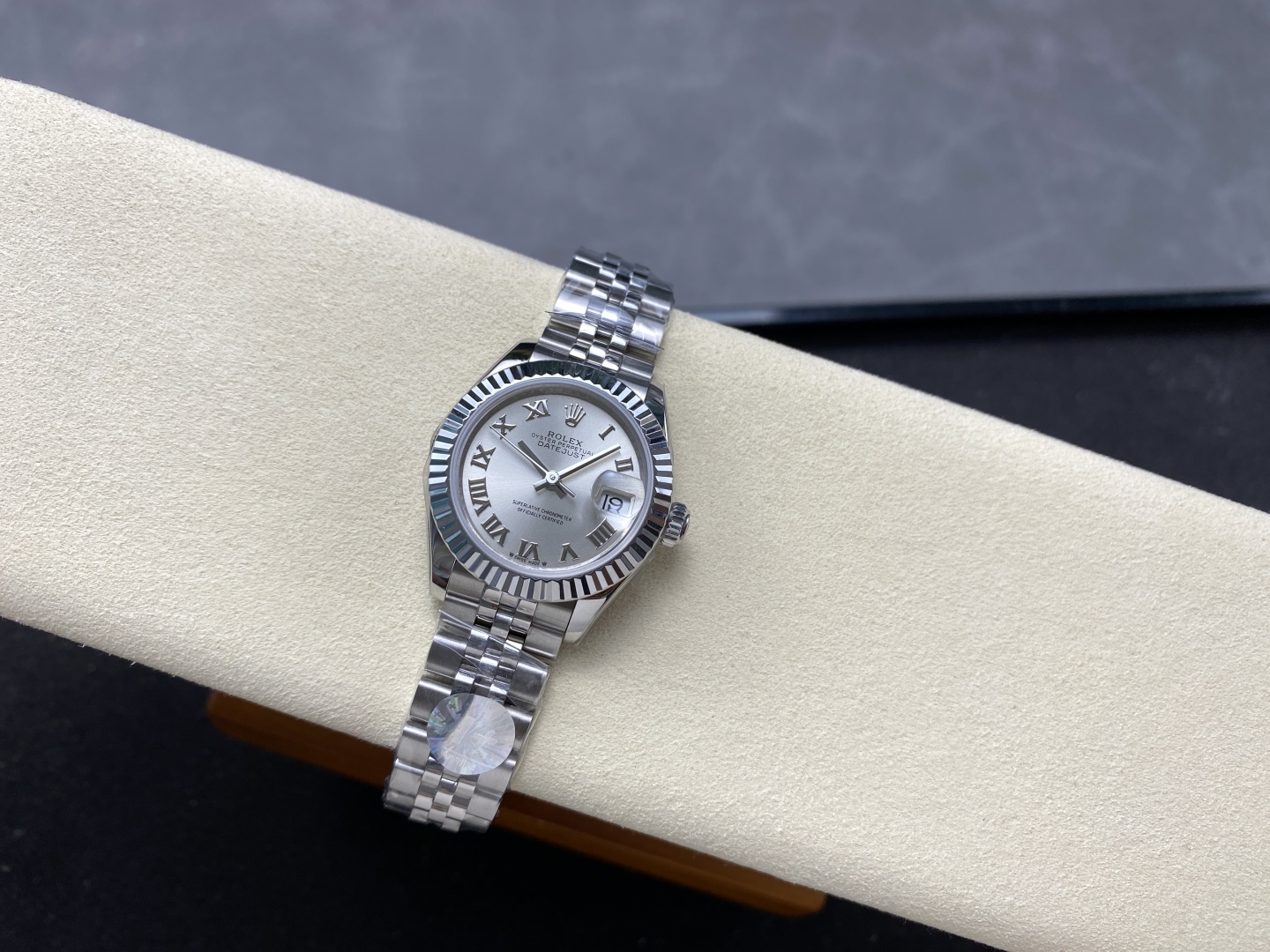 Reloj réplica Rolex Datejust sobre cojín de terciopelo beige