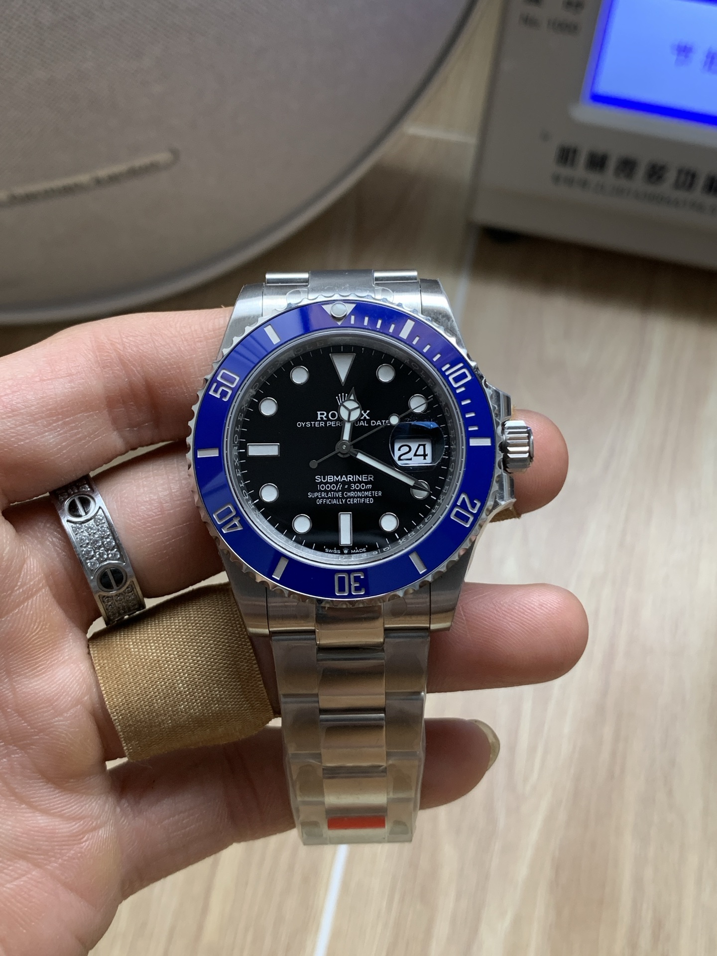 Blue bezel Submariner style replica Rolex on wrist with black dial and date window
