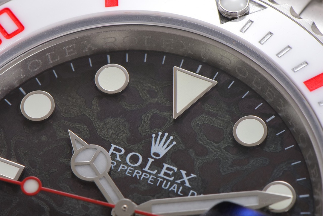 Close-up of the textured black dial, luminous hour markers and hands on a Rolex Submariner or GMT watch