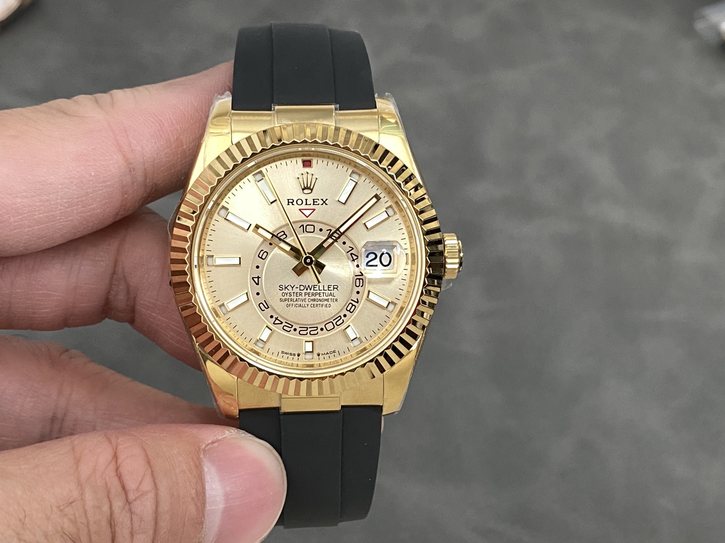 Gold Rolex Sky-Dweller Super-Clone replica with champagne dial and black Oysterflex strap on wrist