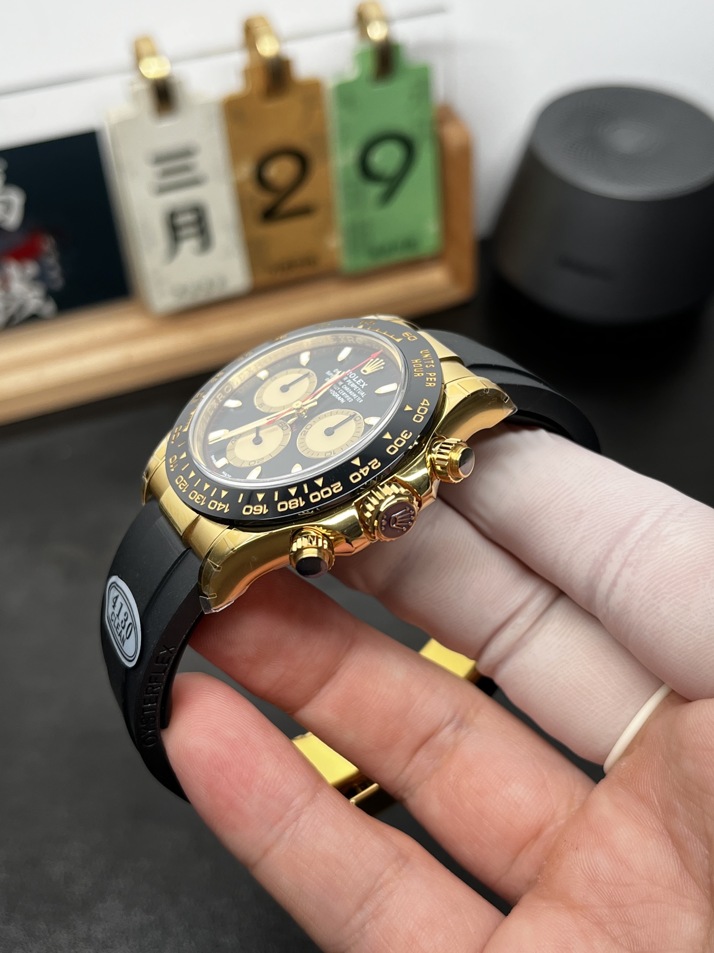 Clean Factory Rolex Daytona replica in yellow gold with black Oysterflex strap angled wrist view