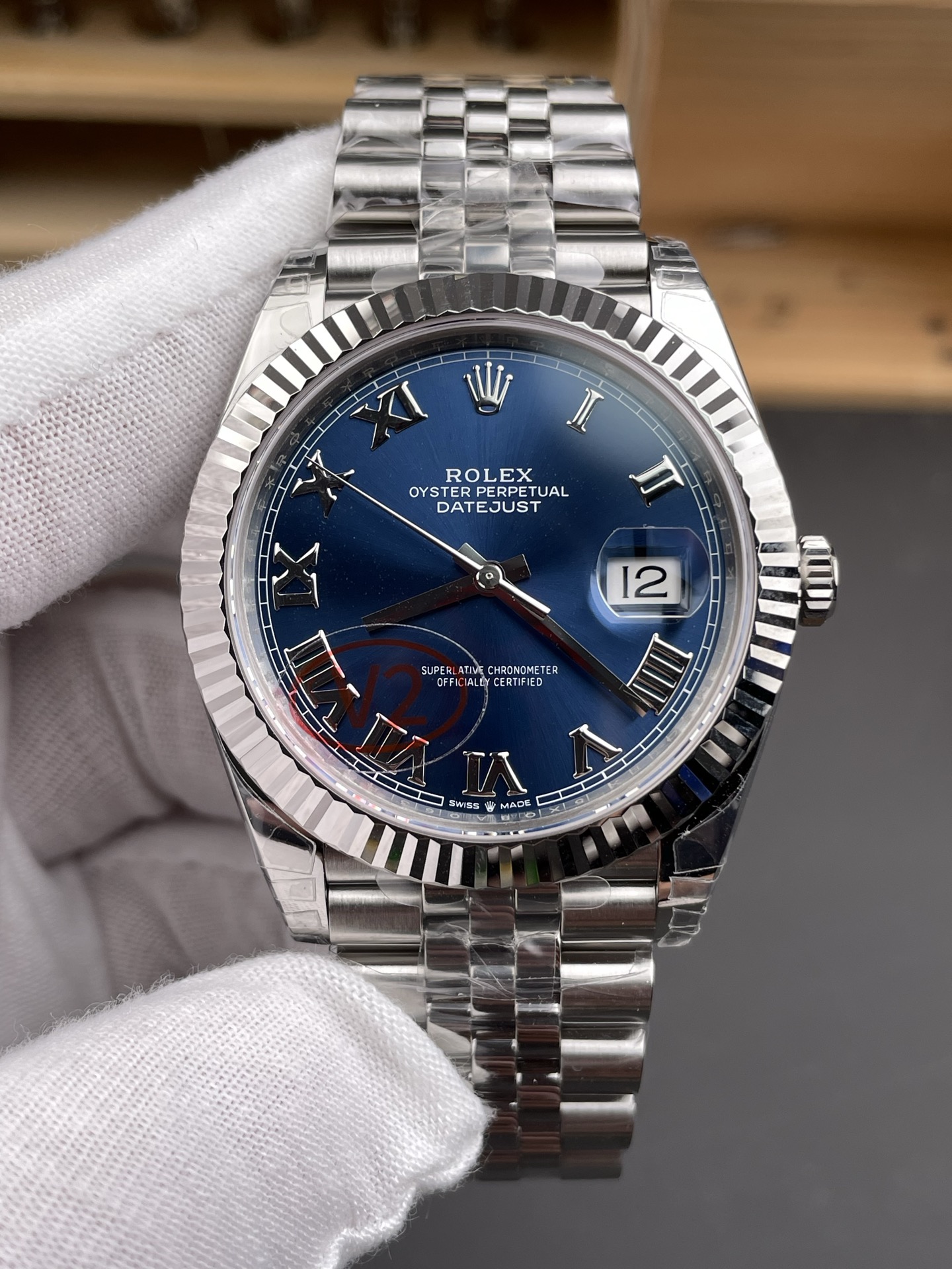 Close front view of blue Datejust rolex replica watches dial with Roman numerals cyclops and fluted bezel