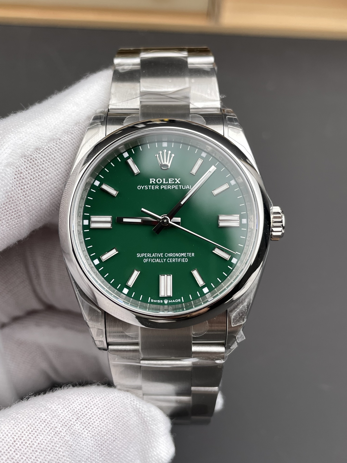 Gruenes Rolex Oyster Perpetual Zifferblatt mit polierter Stahl-Luenette in frontaler Nahaufnahme