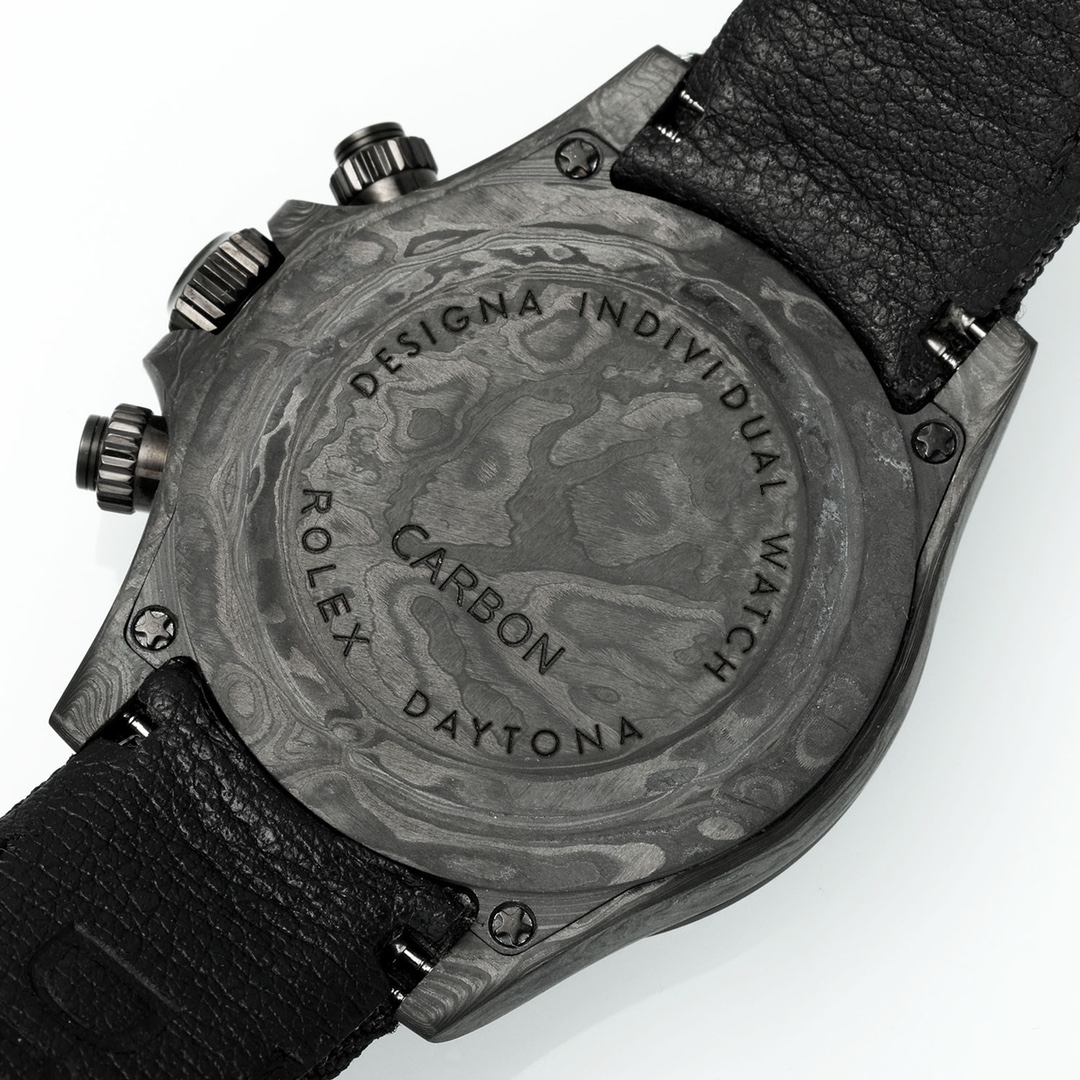 Angled view of the replica watch caseback made of carbon fiber with engraved text including ROLEX, DESIGN, CARBON, DAYTONA and Torx screws