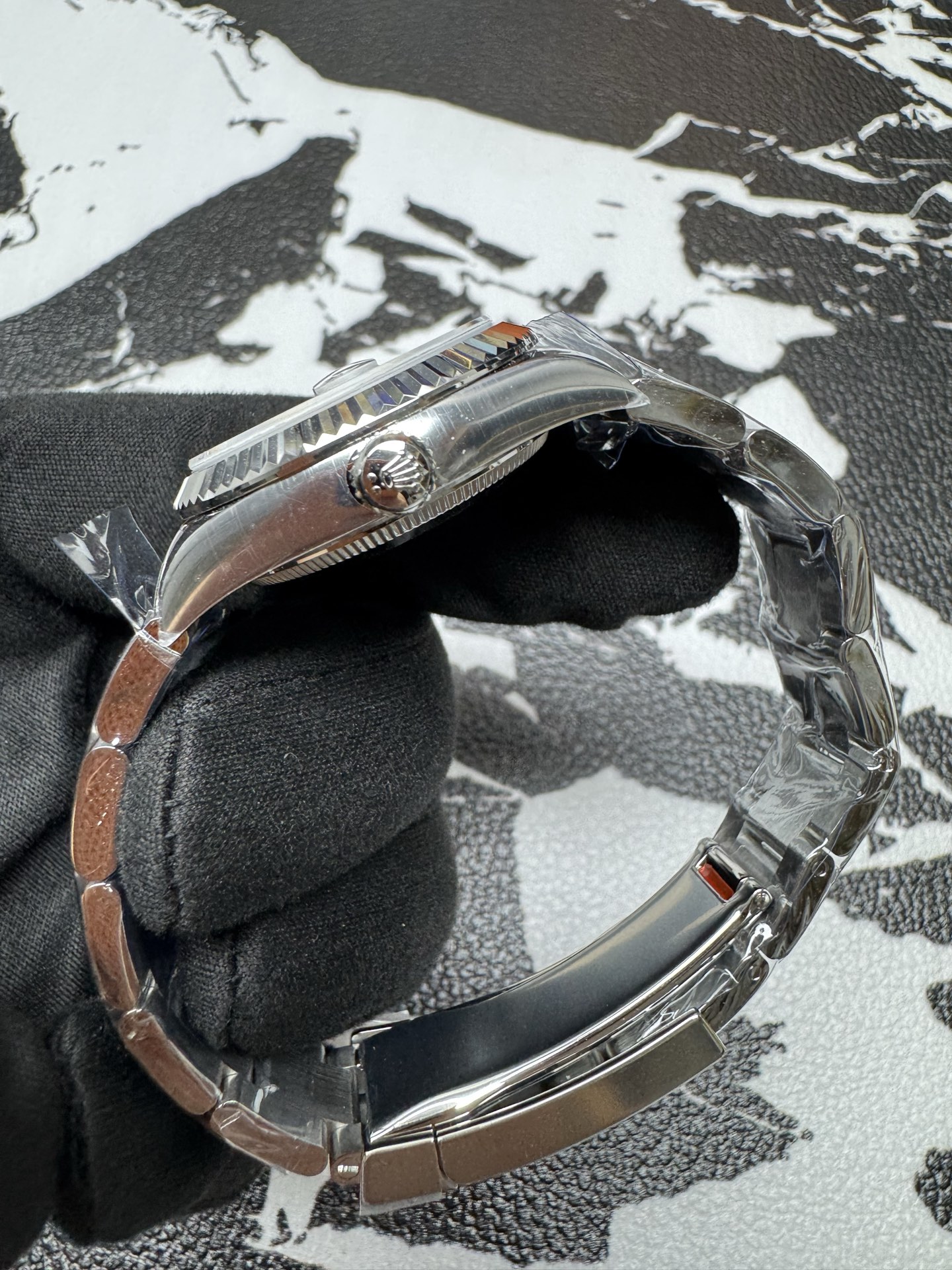 Side profile showing the fluted bezel and winding crown on a Clean Factory Datejust.