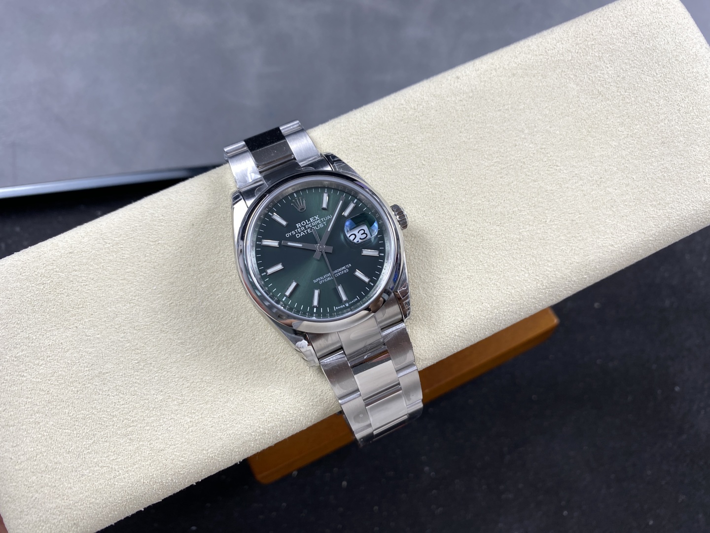 Green dial Rolex Datejust super clone on a cream watch cushion with steel bracelet