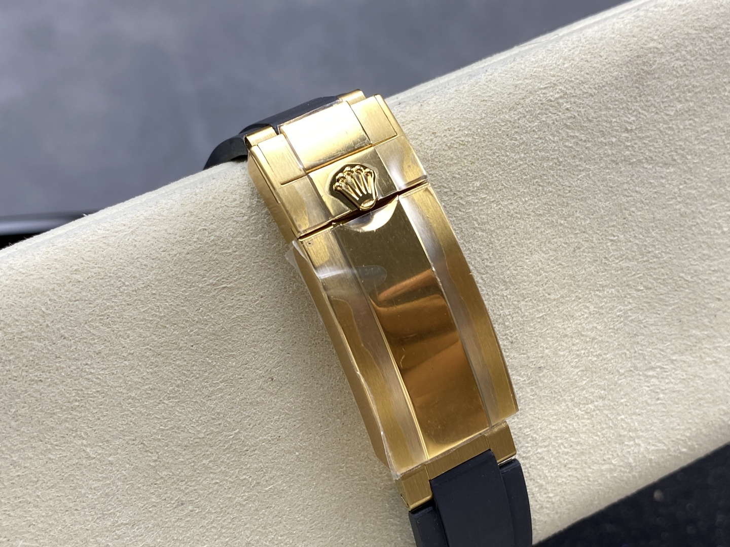 Close-up detail of premium gold folding clasp with Rolex crown logo on black rubber strap showing authentic finishing