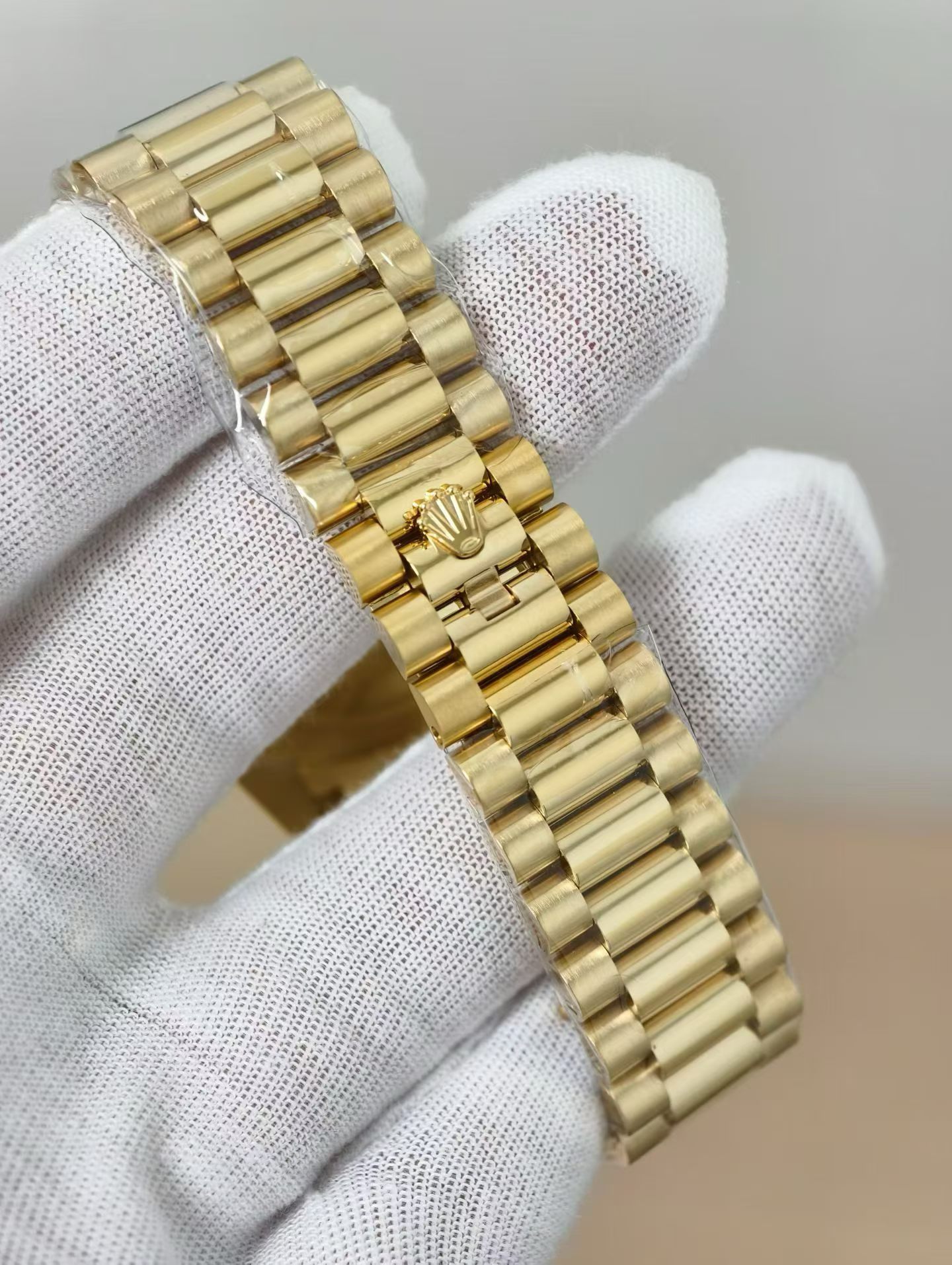 Polished gold Rolex Day-Date replica with deep green dial, fluted bezel, and day display showing FRIDAY