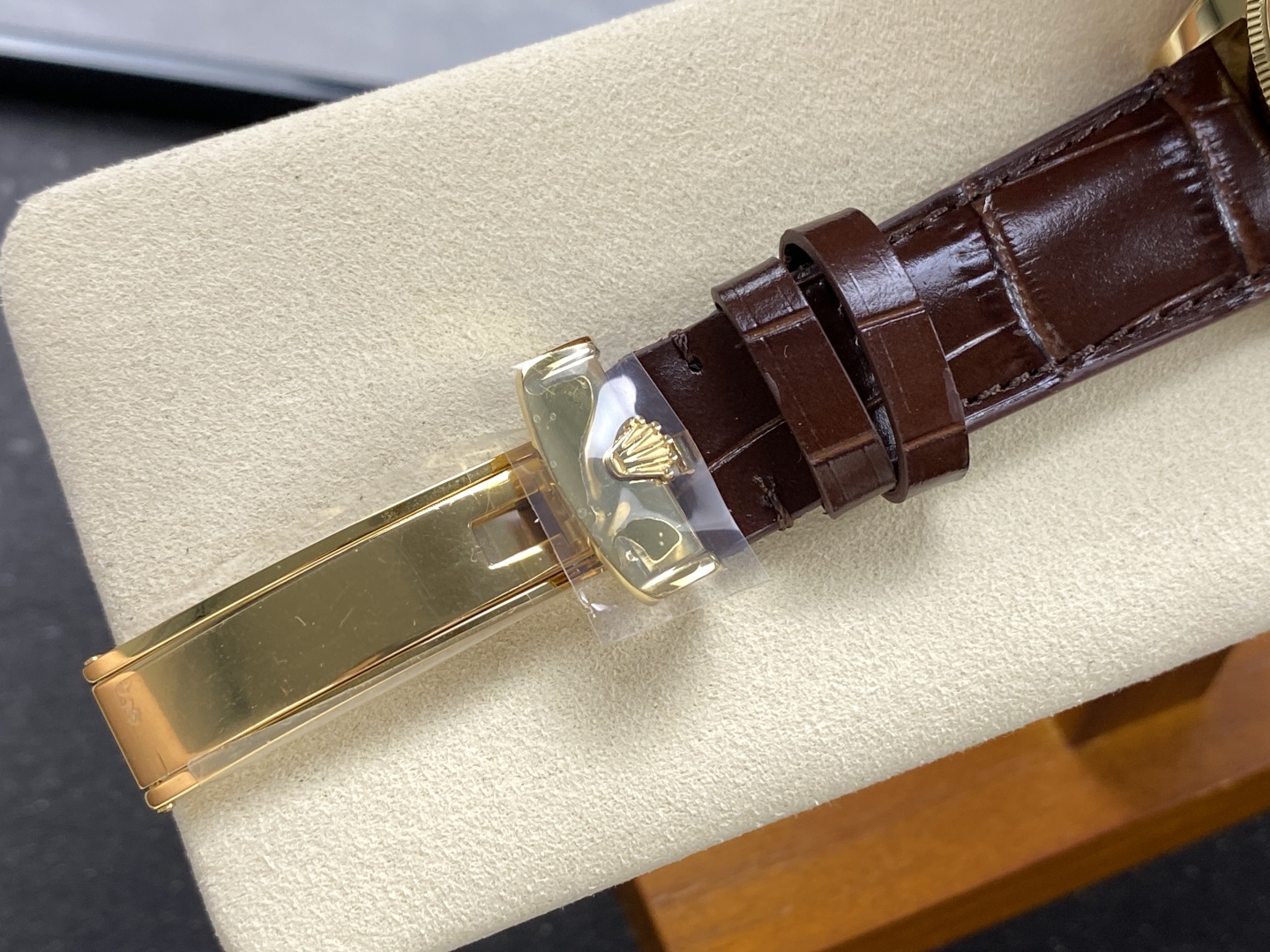 Goldfarbene Faltschließe und braunes Lederband einer Rolex 1908 Replik mit Kronenlogo und Schutzfolie