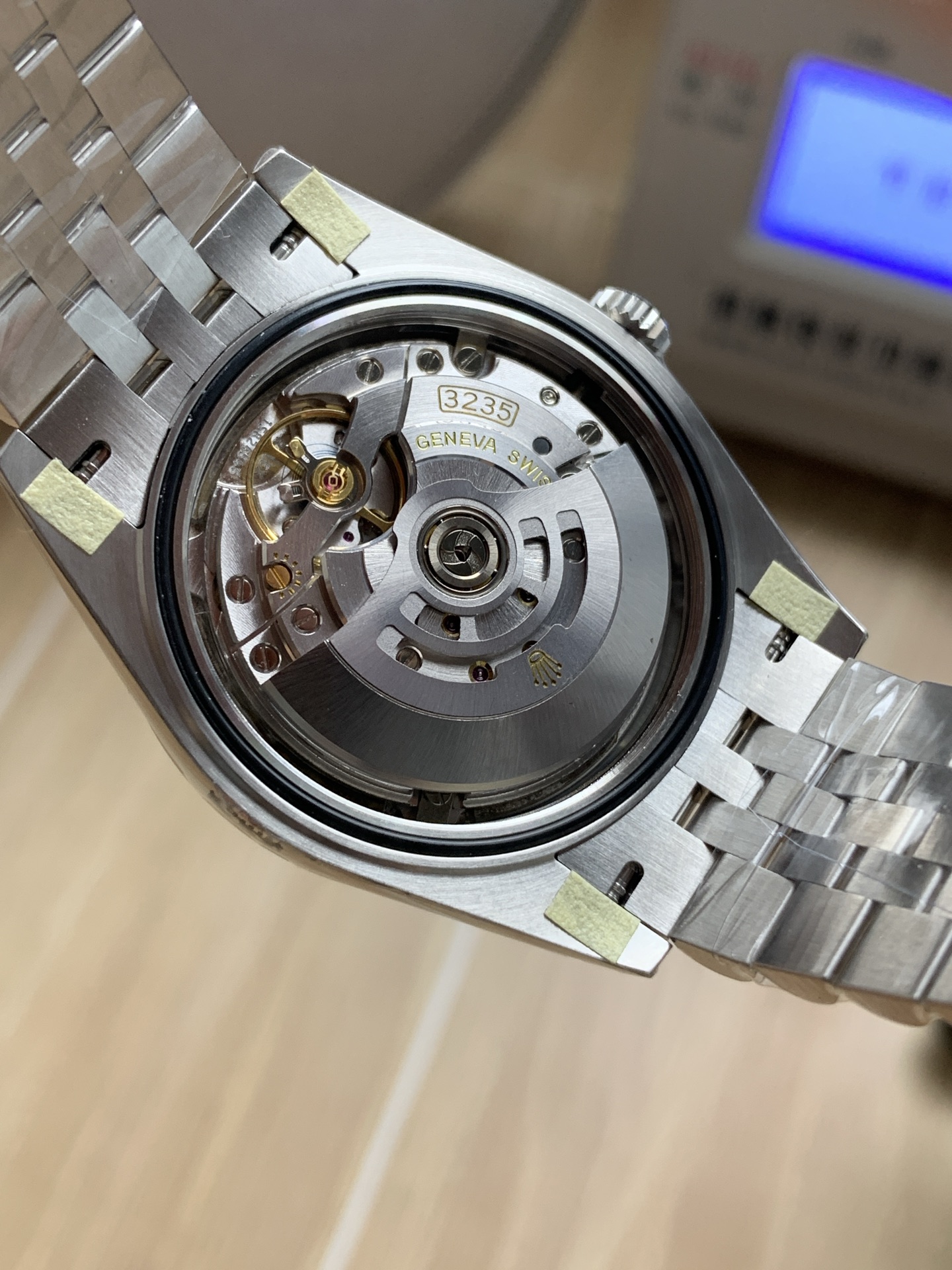 Close-up of the 3235 clone movement showing the rotor, bridges, and engraved text