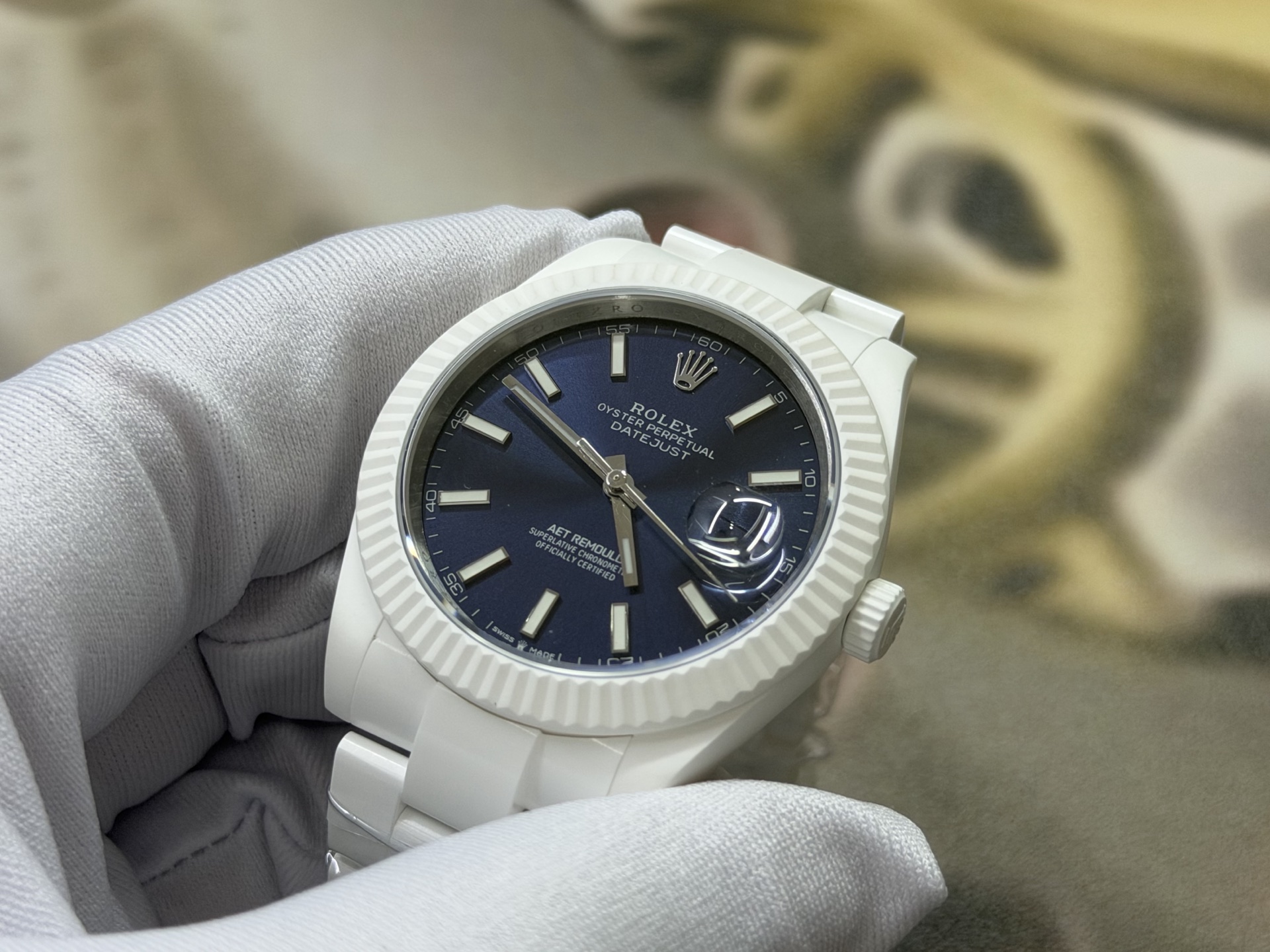 White gloved hand holding a Rolex Datejust replica with a blue dial and fluted bezel