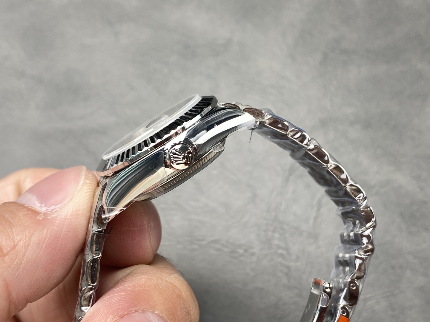 Vista lateral del reloj clon 1:1 con corona Rolex y brazalete jubilee