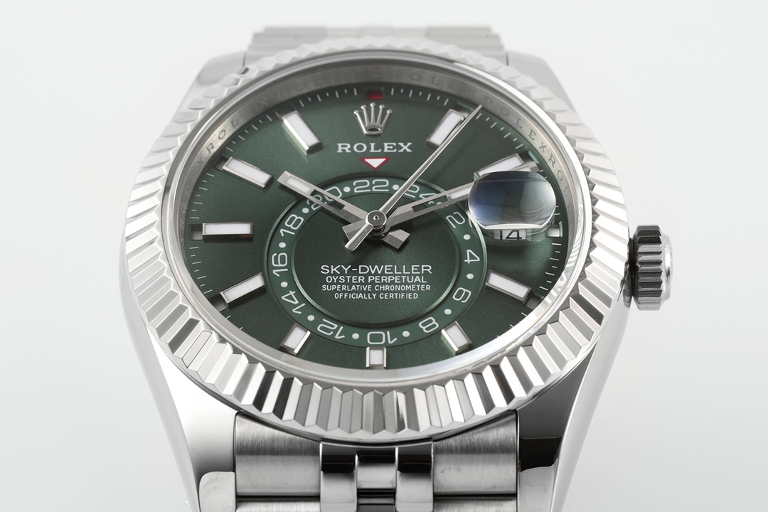 Close-up of Rolex Sky-Dweller green sunburst dial with 24-hour sub-dial, date window showing 14, luminous markers and hands on white background