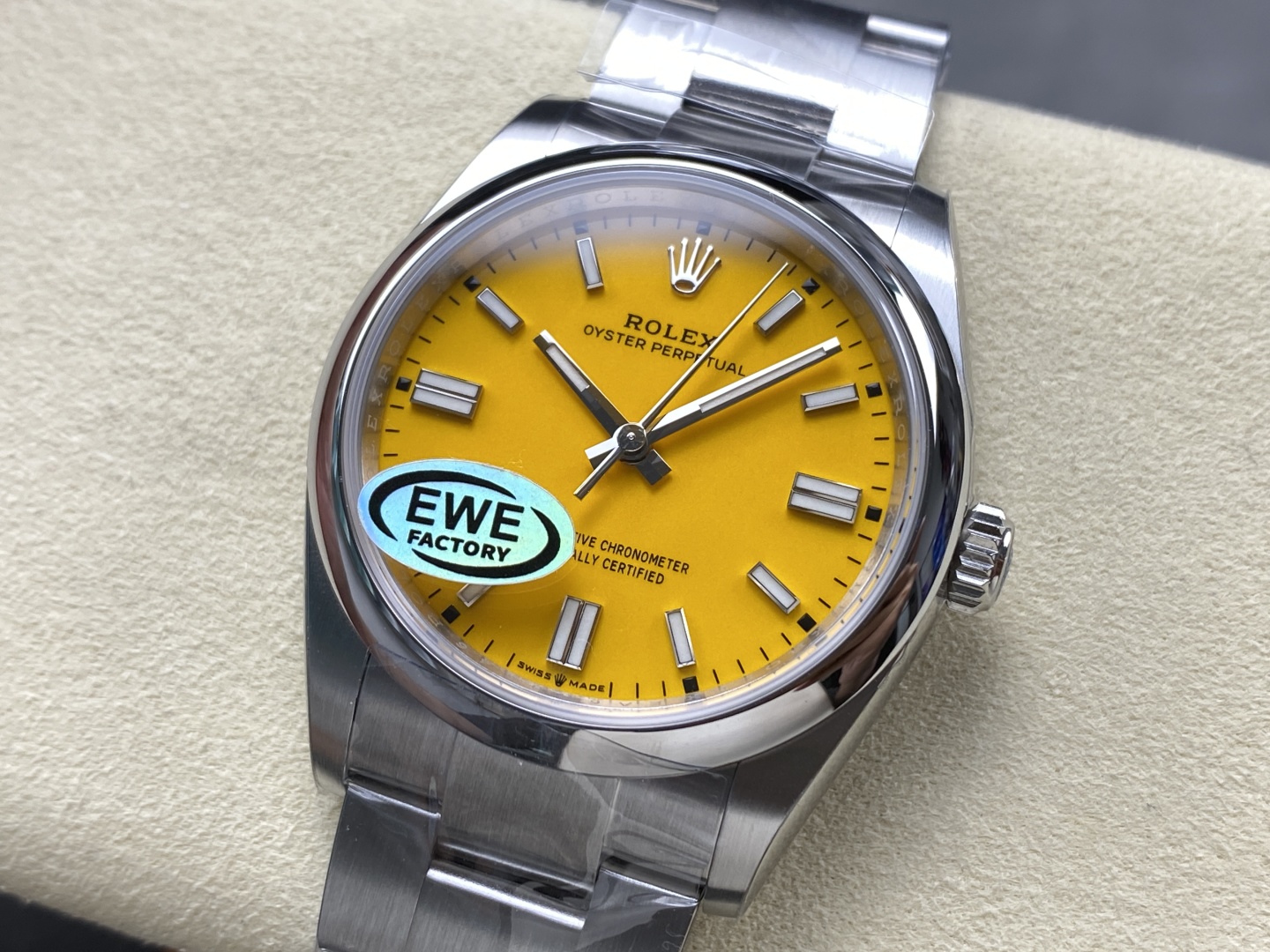 Macro close-up of the bright yellow dial on this quality replica Rolex, showing the applied baton markers, hands, and EWE FACTORY authenticity sticker