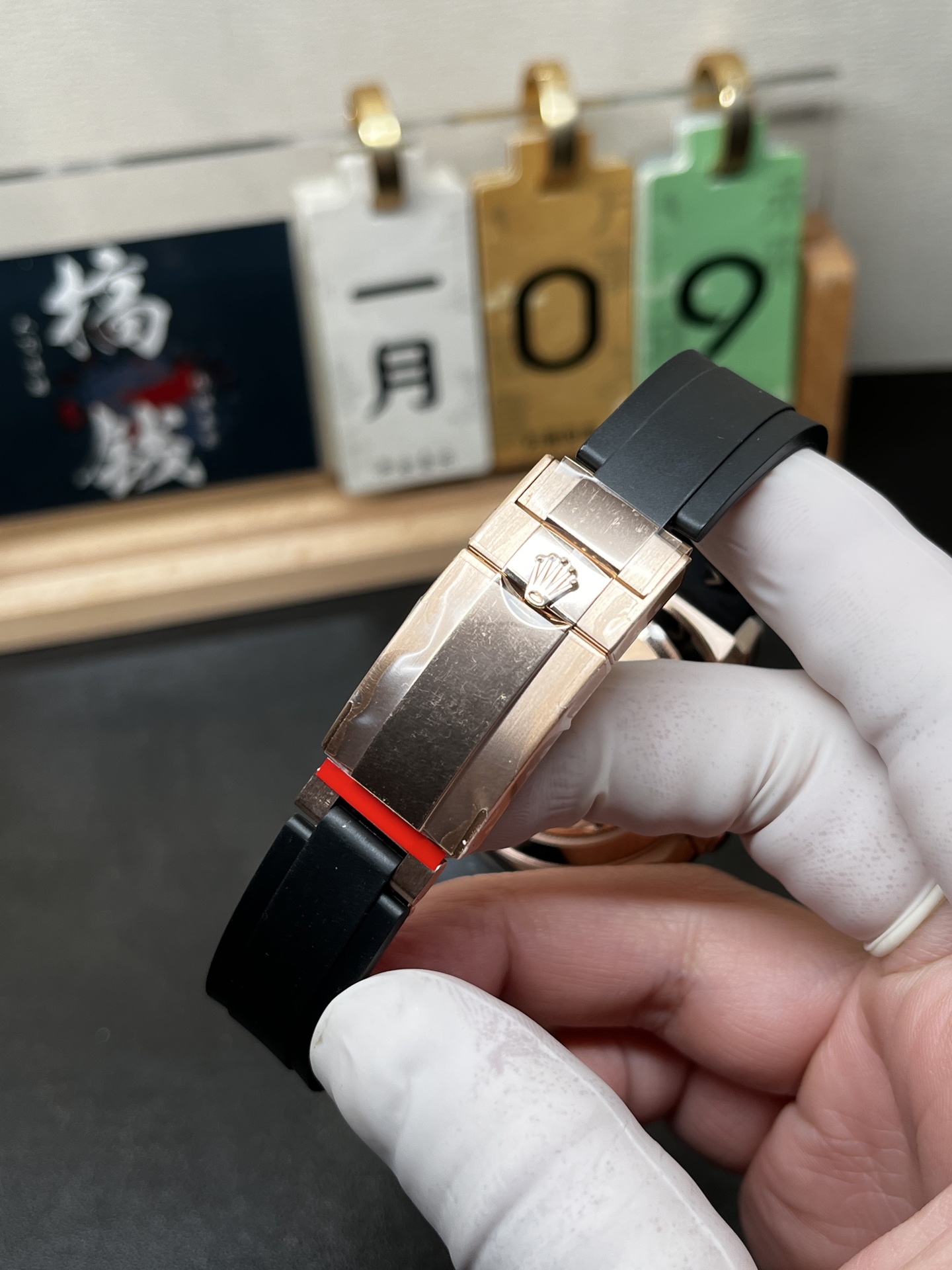 Rose gold Rolex replica clasp with black rubber strap close-up