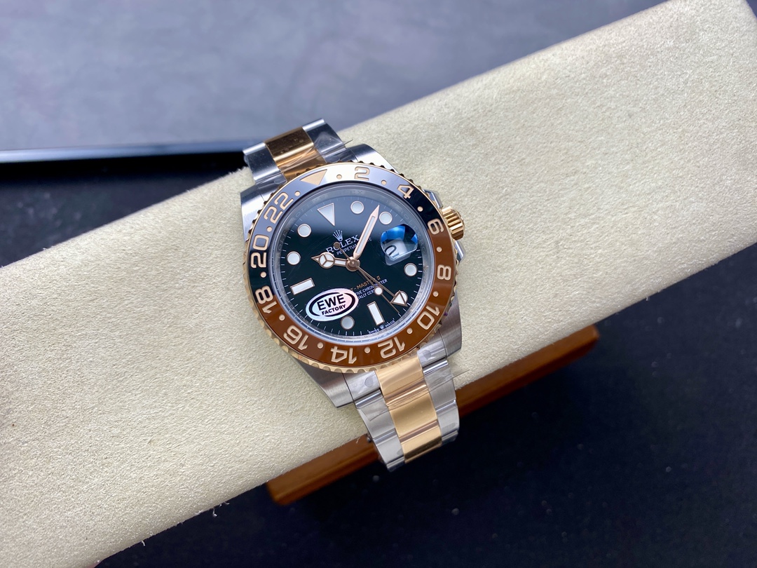 Two-tone Rolex GMT-Master II super clone watch with black dial, brown bezel insert, and polished gold accents on cream display cushion