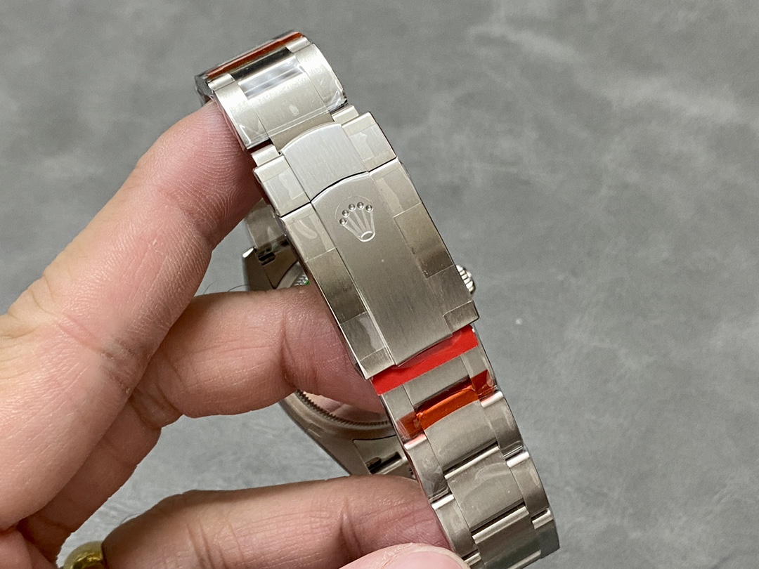 Rolex Oyster Perpetual bracelet clasp with red protective plastic wrap