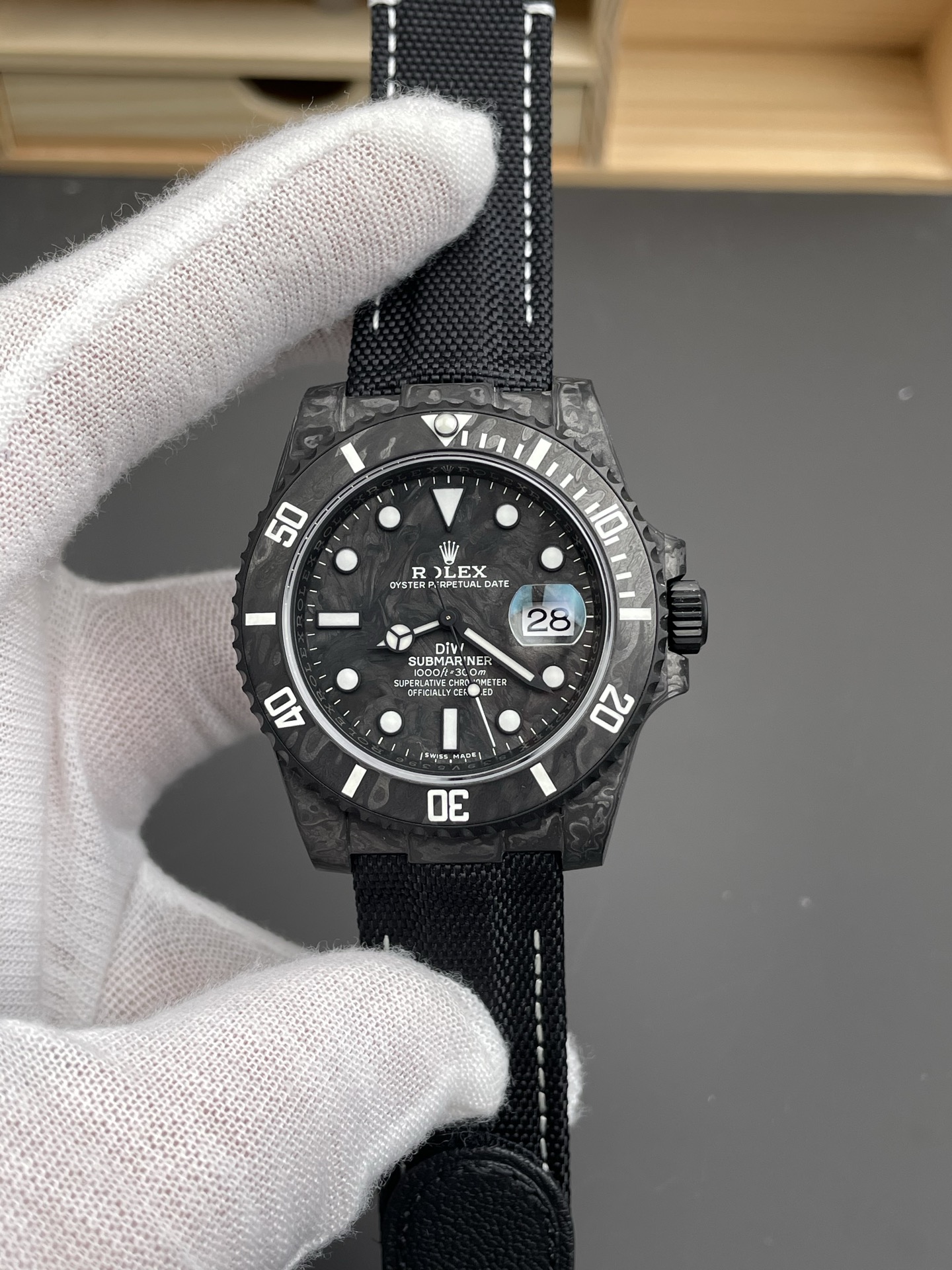 Vue de face de la réplique Rolex Submariner carbone avec cadran noir et aiguilles blanches