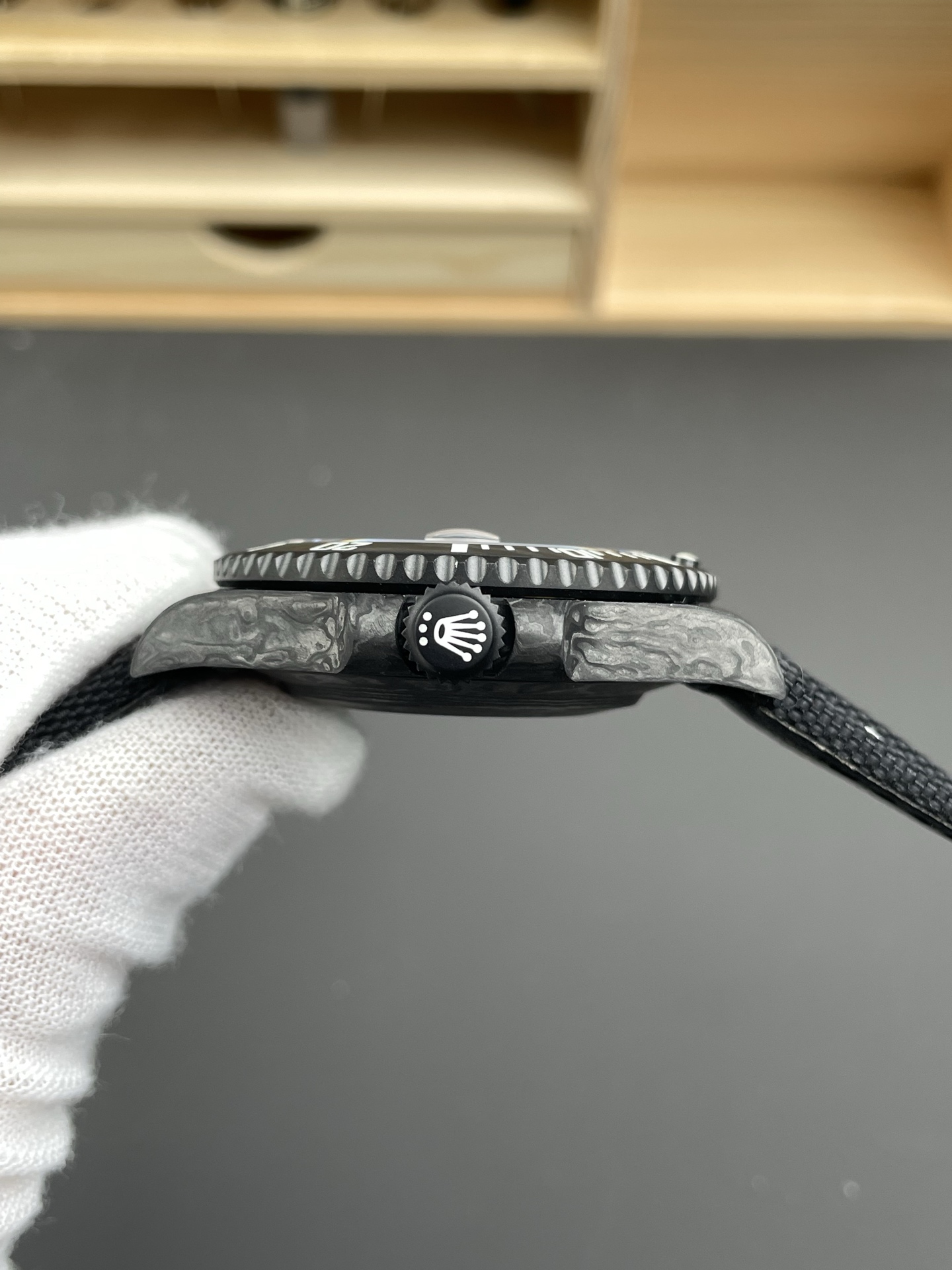 Profil latéral de la réplique Rolex Submariner carbone avec couronne vissée et bracelet noir