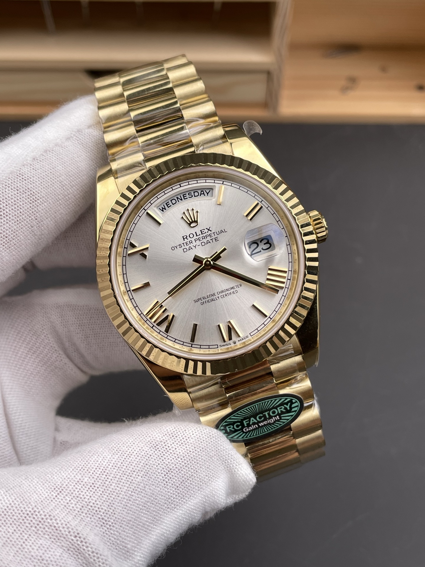 Angled wrist test view of a gold Rolex Day-Date replica with silver dial