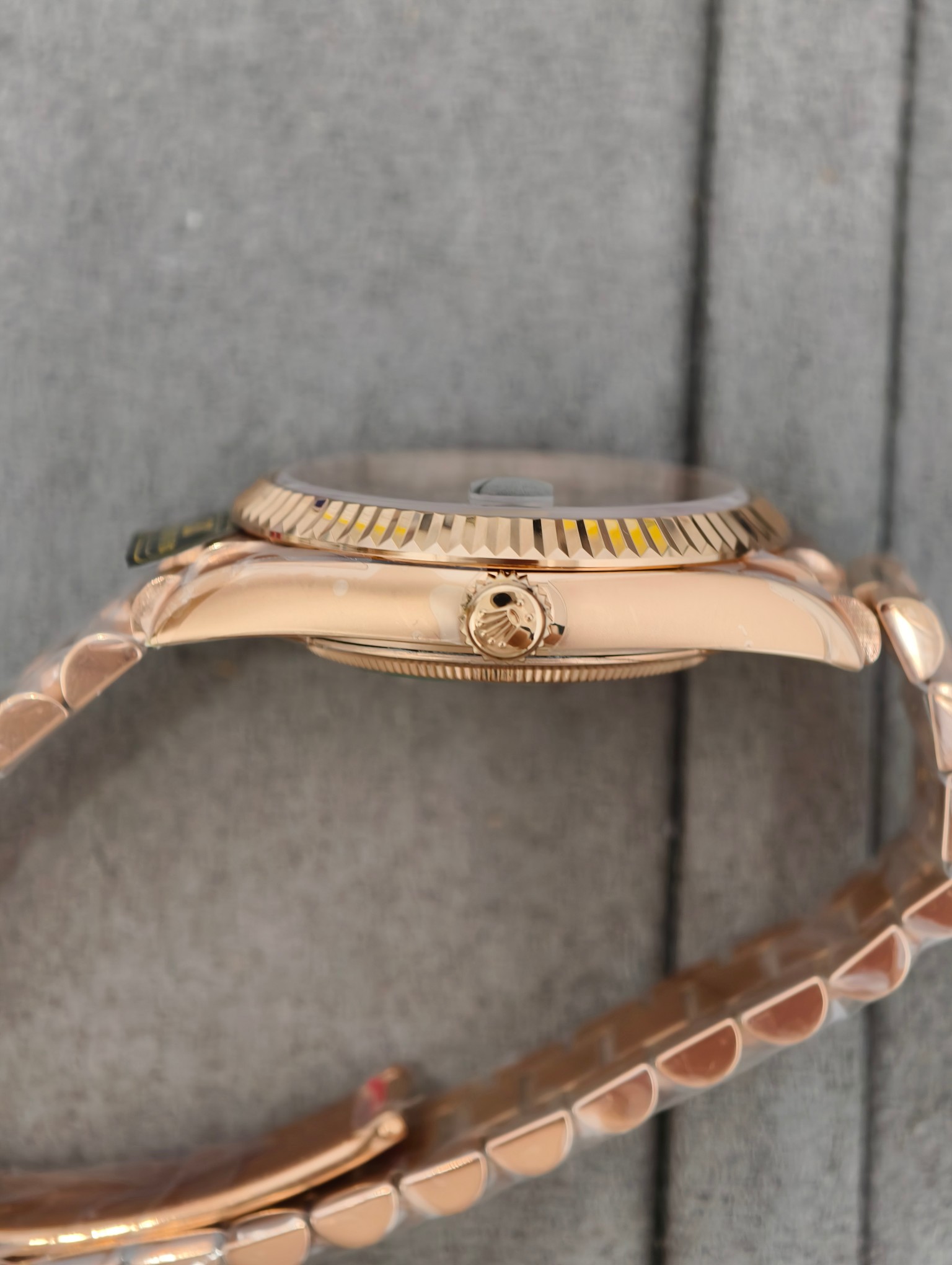 Side profile close-up of the rose gold replica Rolex watch highlighting the fluted bezel, crown and Oyster bracelet