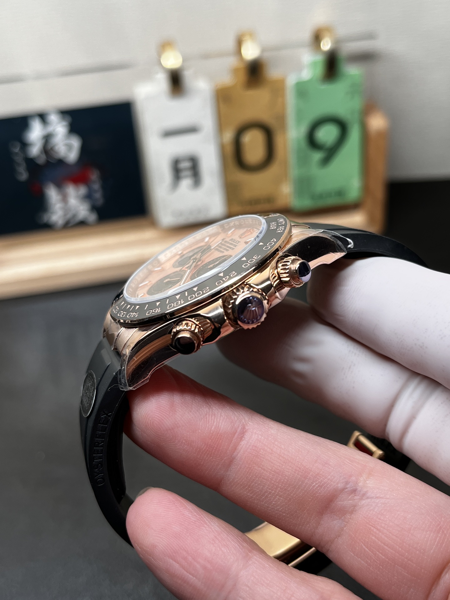 Side profile of rose gold Daytona replica Rolex case and chronograph pushers