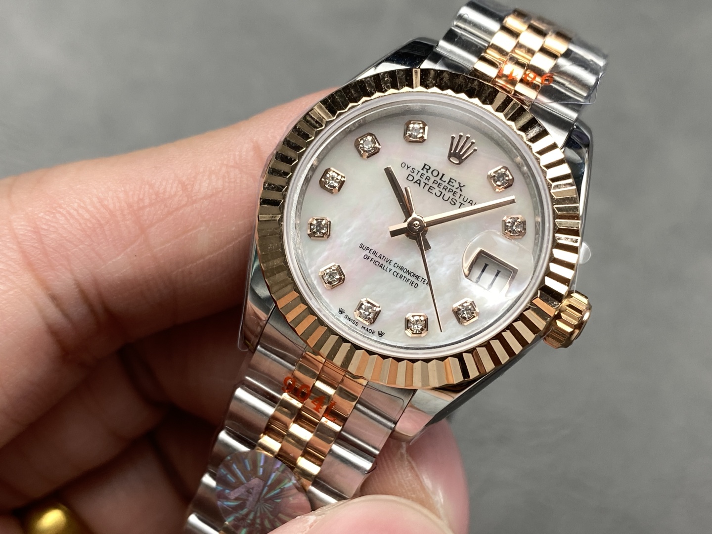 Close-up view of the mother-of-pearl dial featuring diamond markers and the Rolex crown logo on the Datejust 31 replica